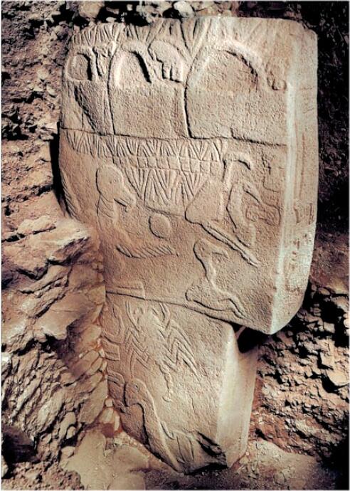Göbeklitepe’deki bir T biçimli dikilitaş üzerinde yer alan hayvan kabartmaları ve sembolik motifler. Arkeolojik kazı alanında toprak arasında duran taş, Neolitik Çağ’dan kalma detaylı oymalar içeriyor.