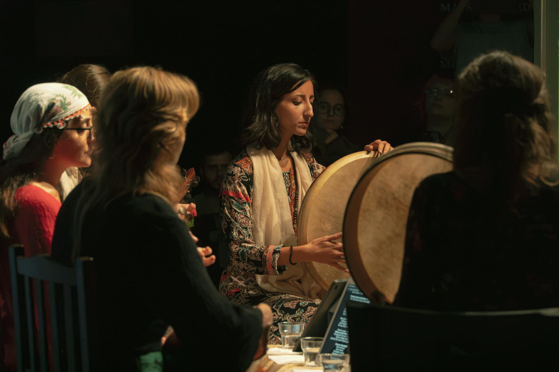 def çalan kadın ve çevresinde dinleyenler