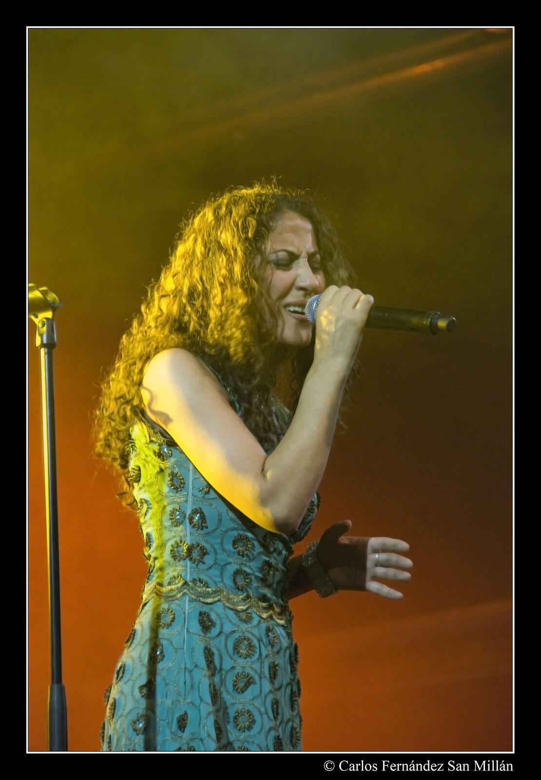 şarkıcı mikrofonla yüksek bir nota okuyor