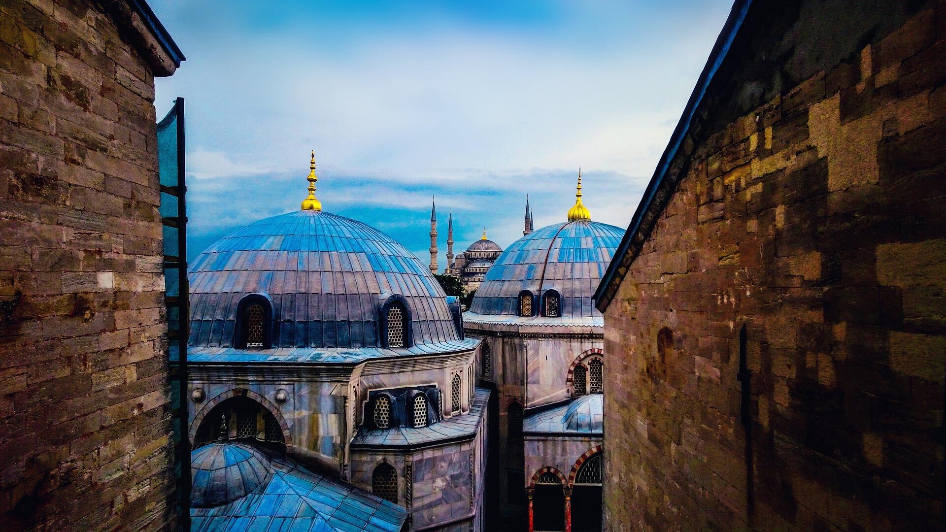 İstanbul’daki Ayasofya ve Sultanahmet Camii kubbeleriyle Osmanlı mimarisinin ihtişamını gösteren tarihi şehir manzarası, Türkiye tarihinin Osmanlı’dan Cumhuriyet’e uzanan kültürel mirasını yansıtır.