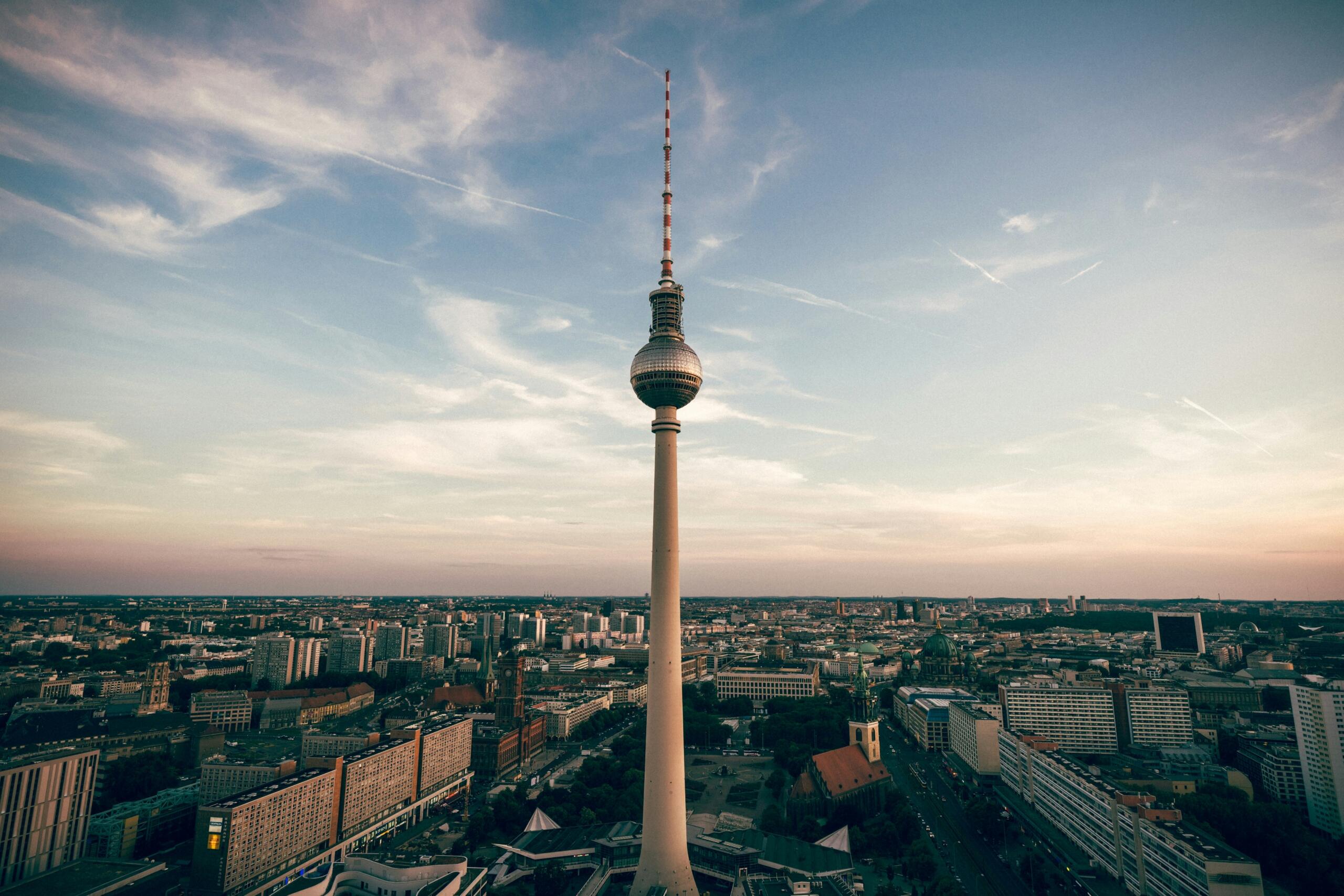 Berlin Televizyon Kulesi (Fernsehturm), şehrin üzerinde yükselirken arka planda Berlin’in geniş şehir manzarası görülüyor.