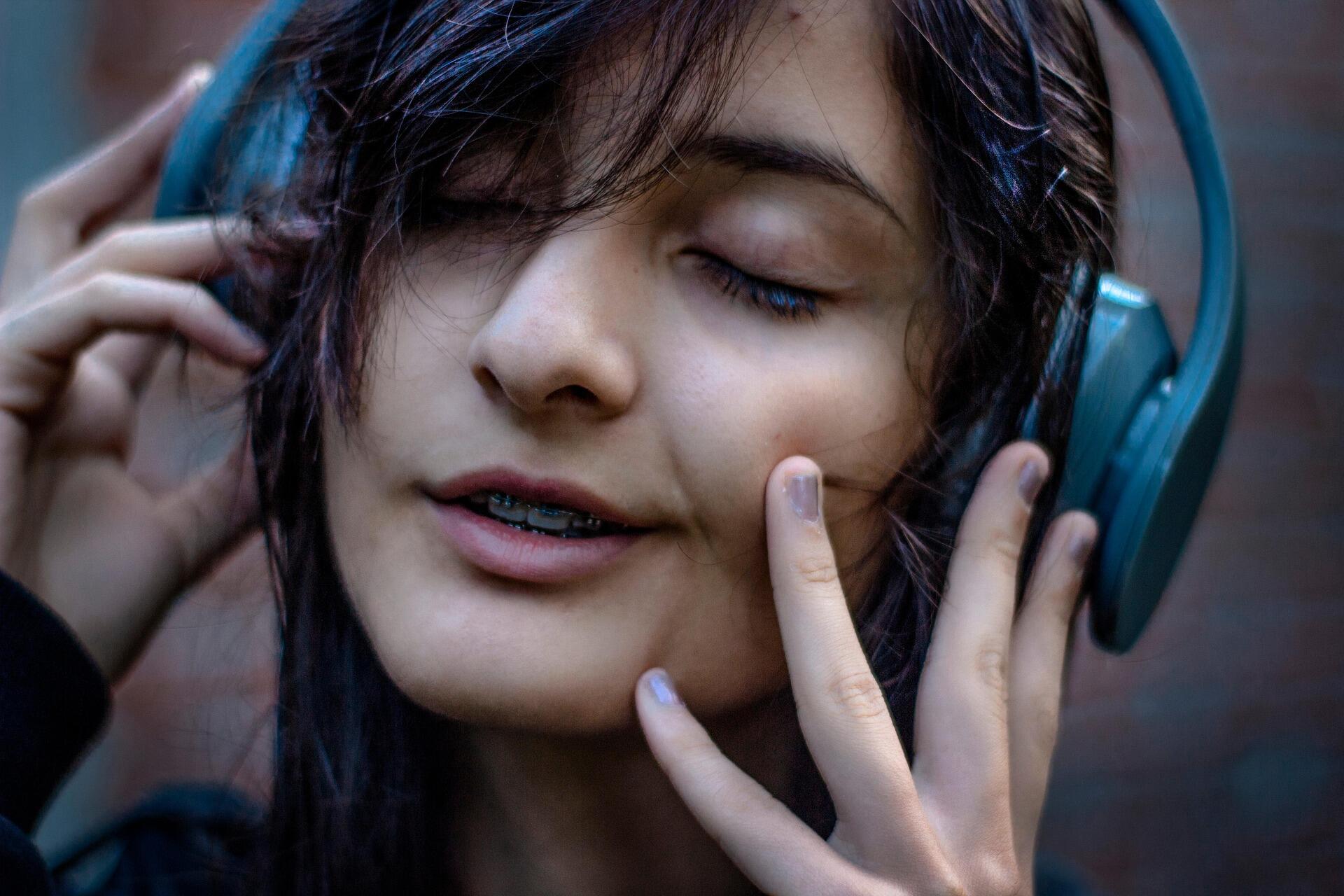 kulaklıkla müzik dinleyen genç kadın gözleri kapalı rahatlıyor