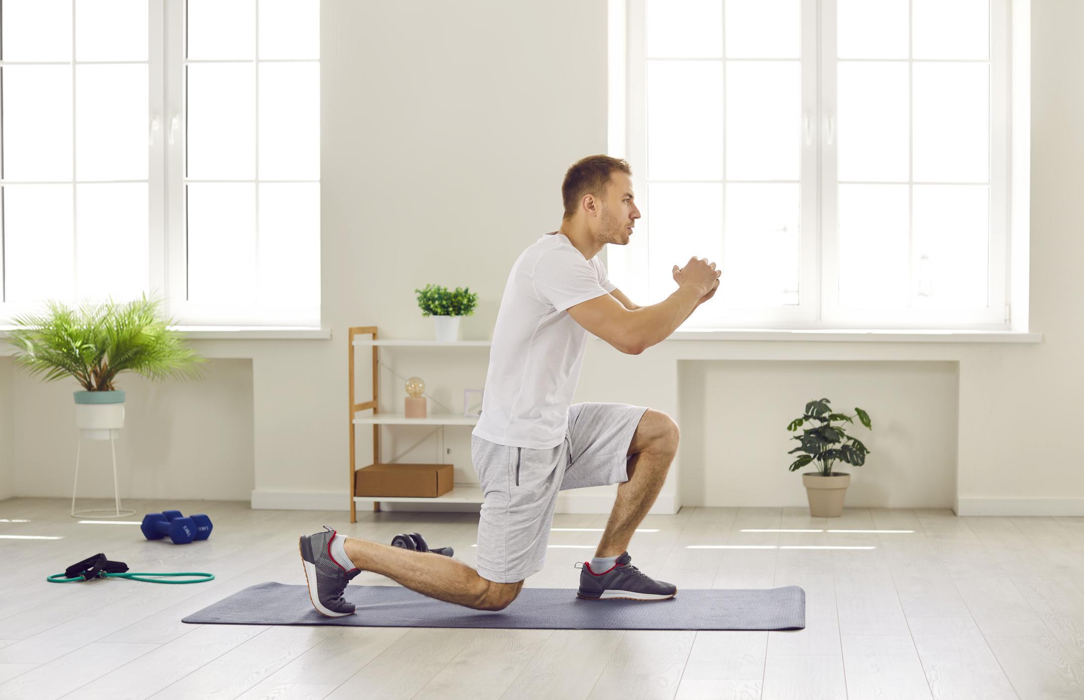 mat üstünde lunge hareketi yapan bir erkek. Evde spor programı