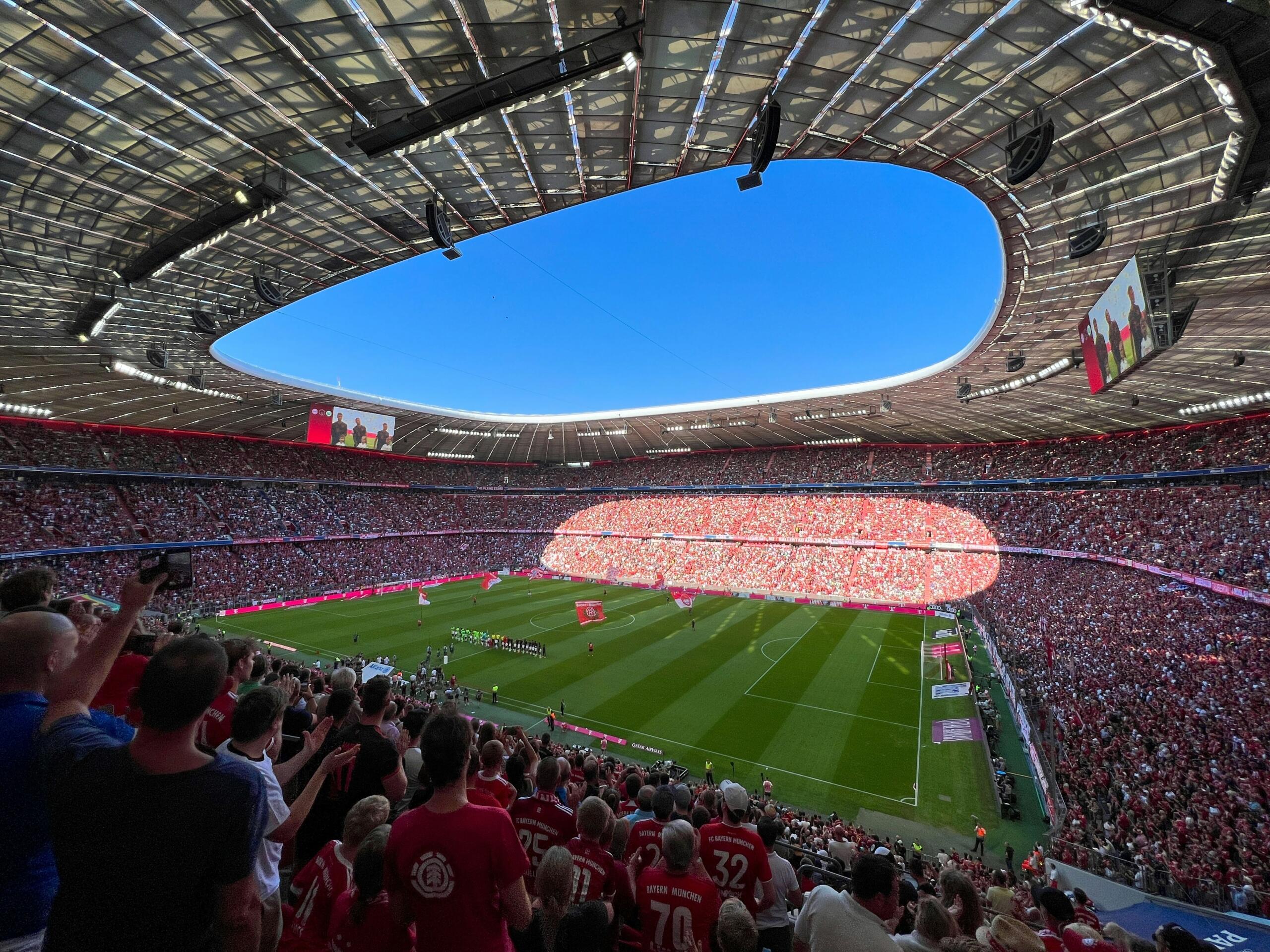 Allianz Arena bundesliga maçları öncesi Bayern Münih taraftarlarıyla dolu tribünler ve yeşil saha