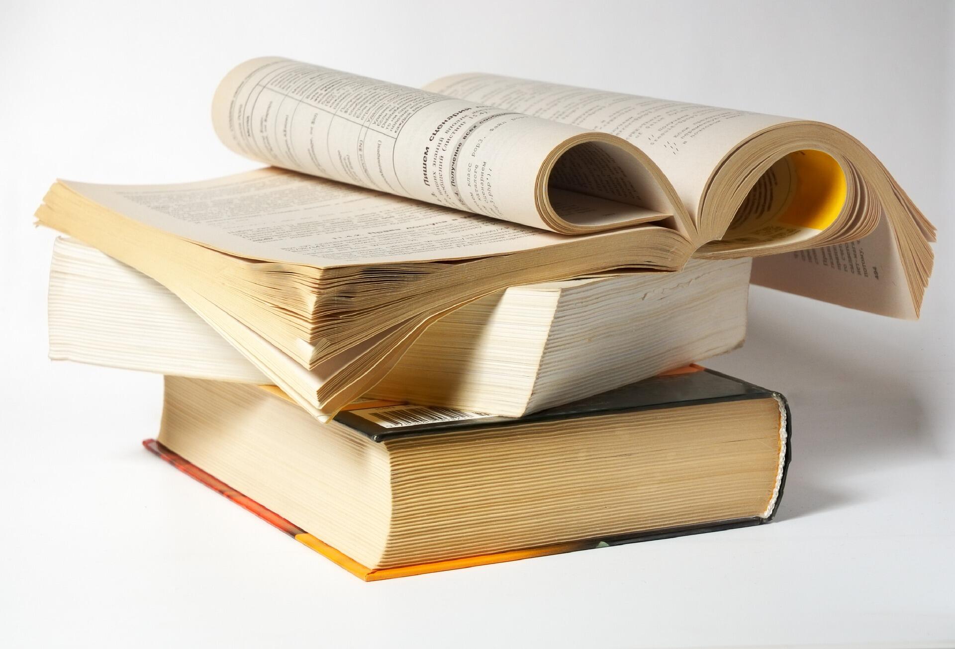 Beyaz zemin üzerine, üç adet ciltli kitabın üst üste konduğu ve en üstteki kitabın sayfalarının kıvrılarak kalp şekli oluşturduğu bir kompozisyon.