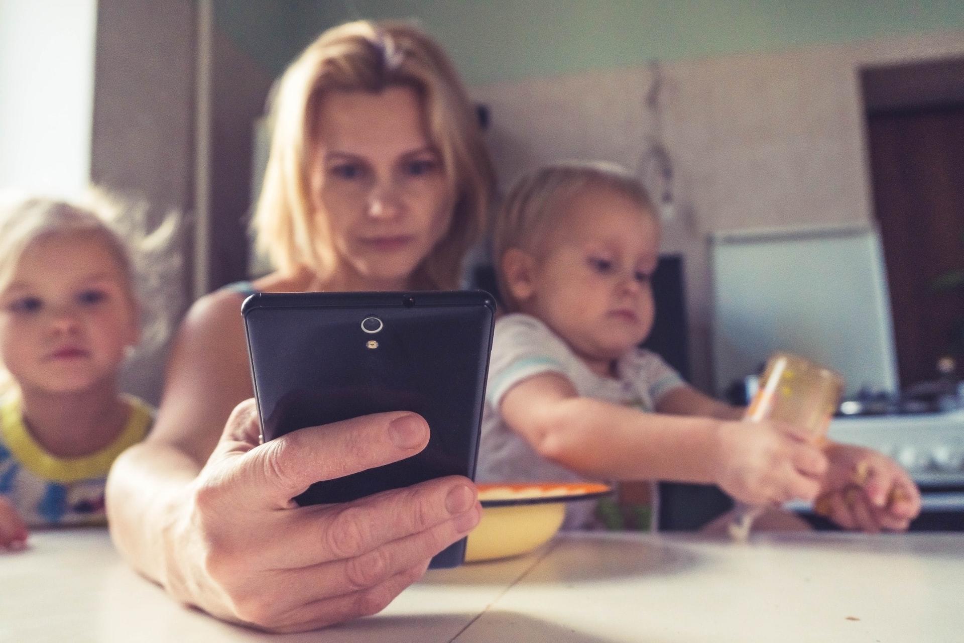 a mother with 2 kids and a gadget