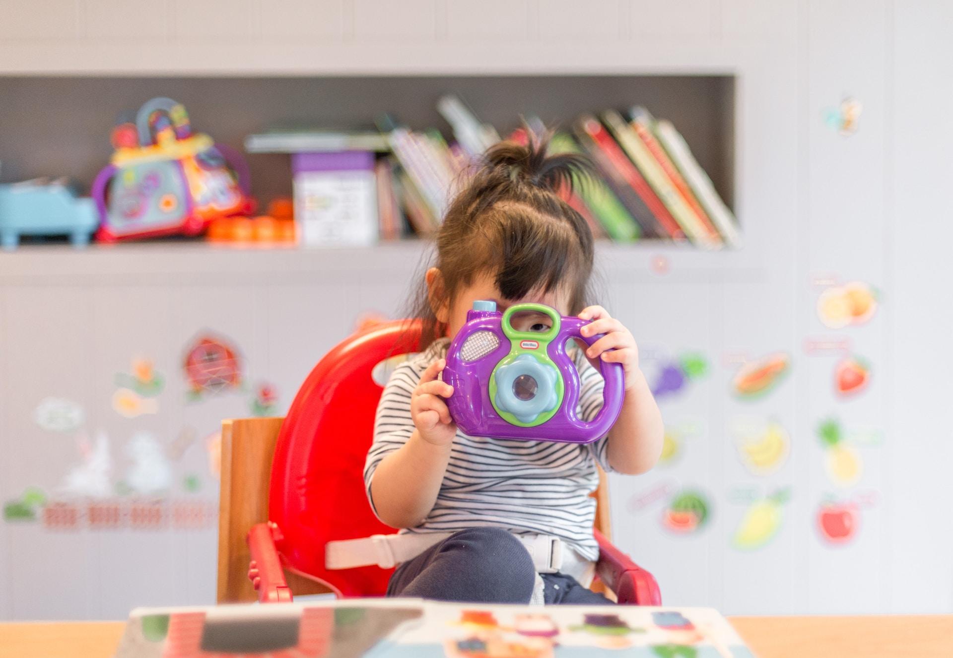 a baby playing with a kid camera