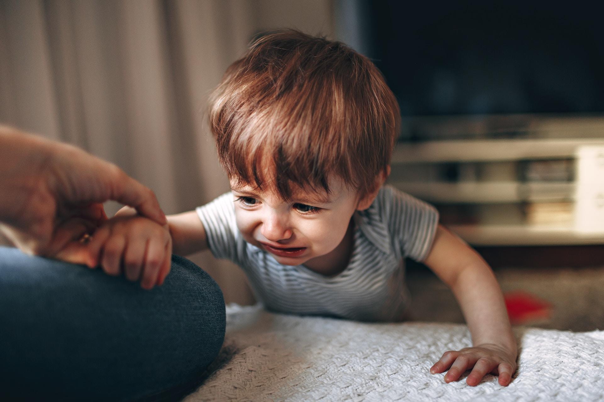 a toddler with his mom holding his hand