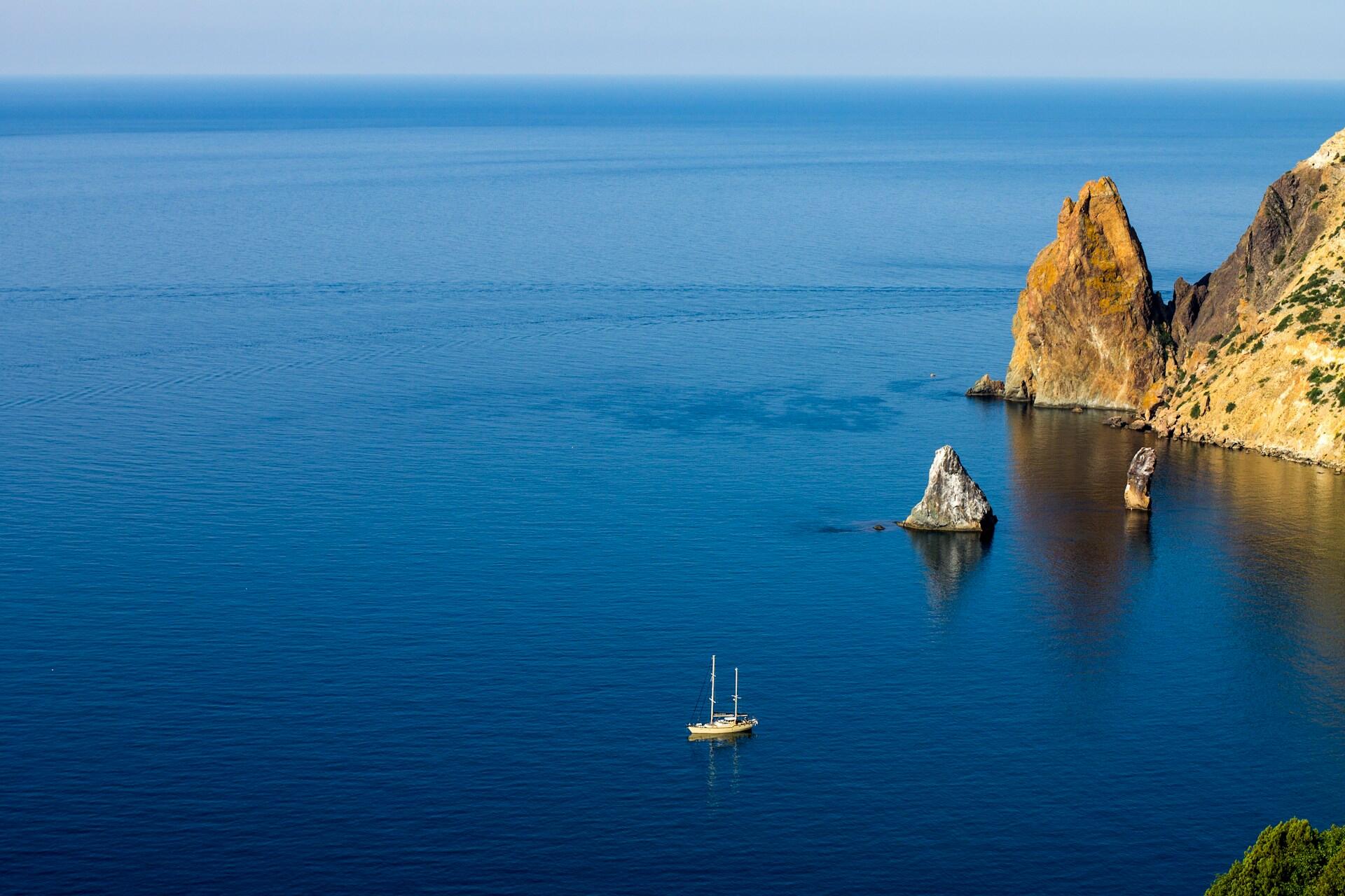 кораблик у морі біля скель
