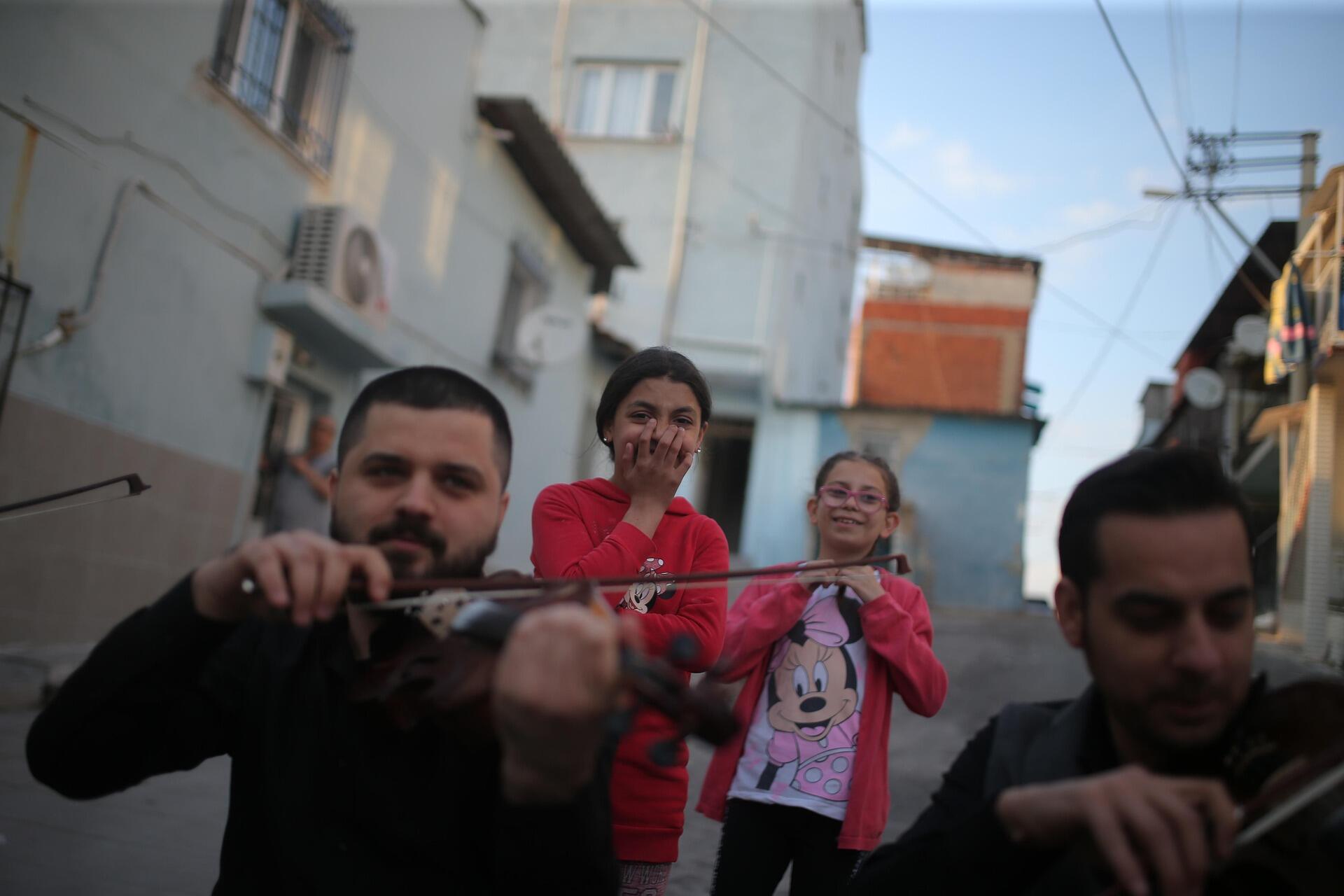 Чоловіки грають на скрипках