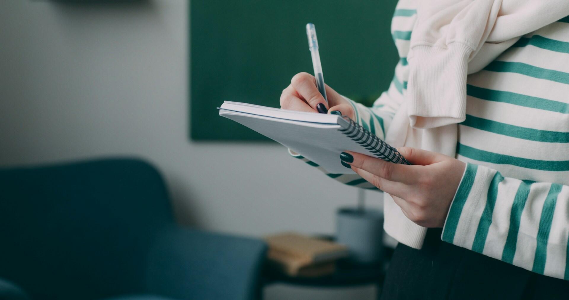 людина нотує у блокноті