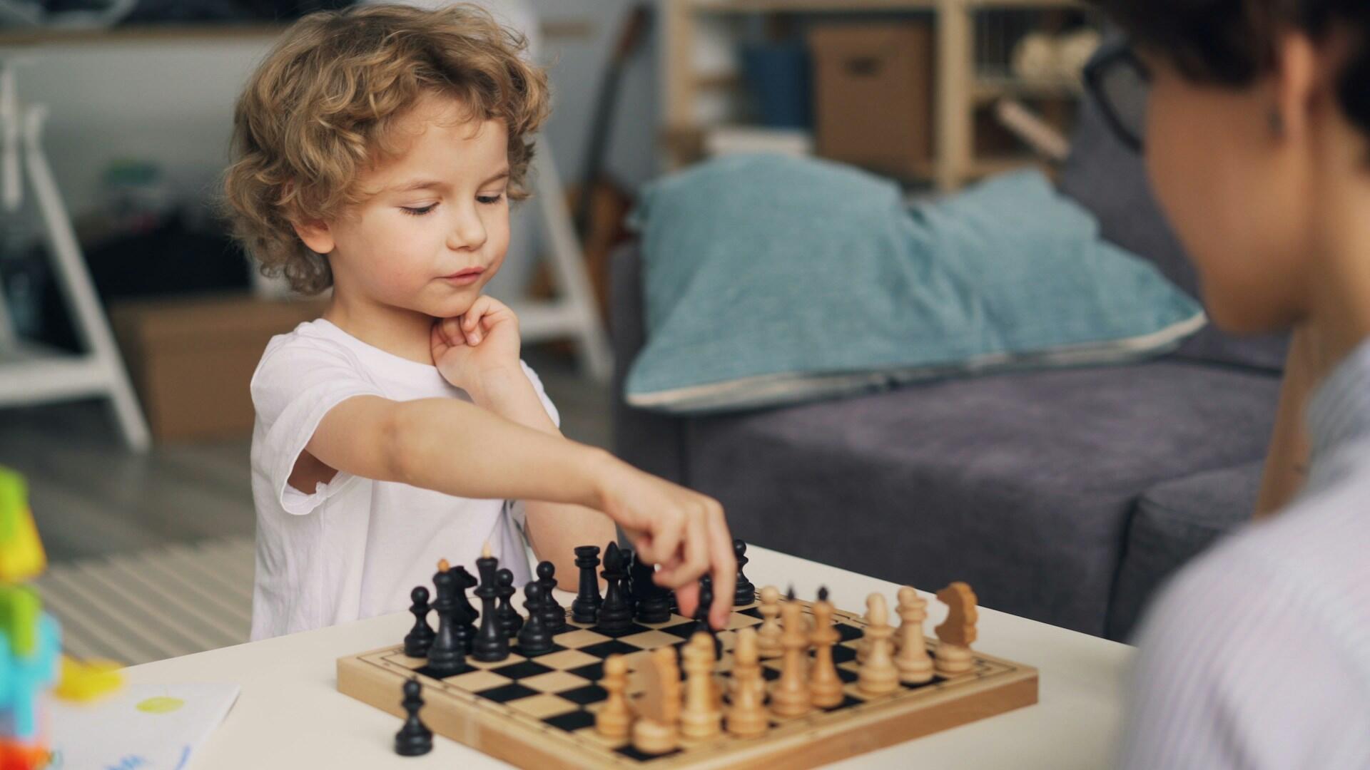 a kid is playing chess