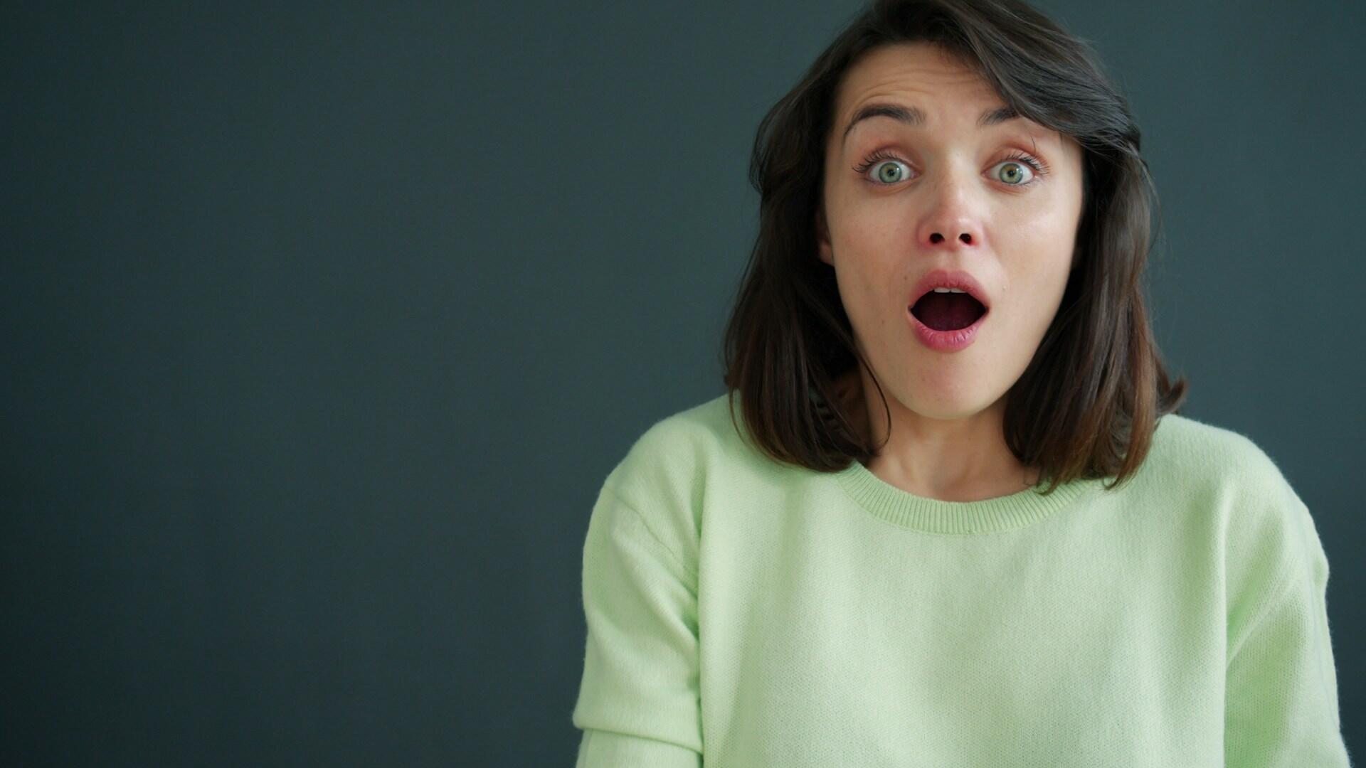a girl in a green sweater showing her surprise