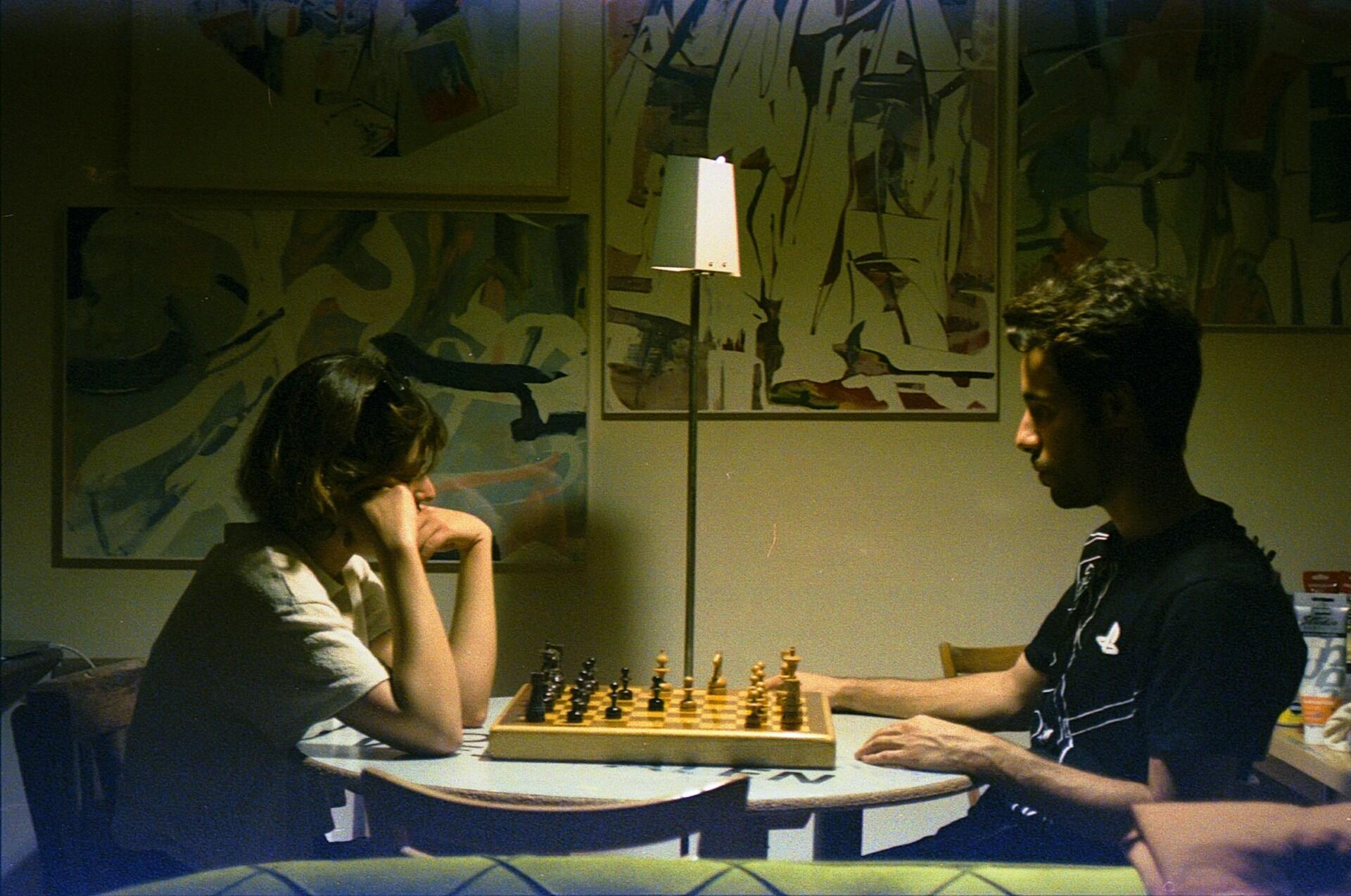 a lady and a man are playing chess