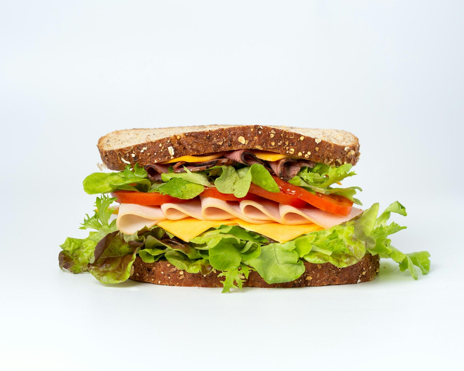 a sandwich with ham, cheese and vegetables