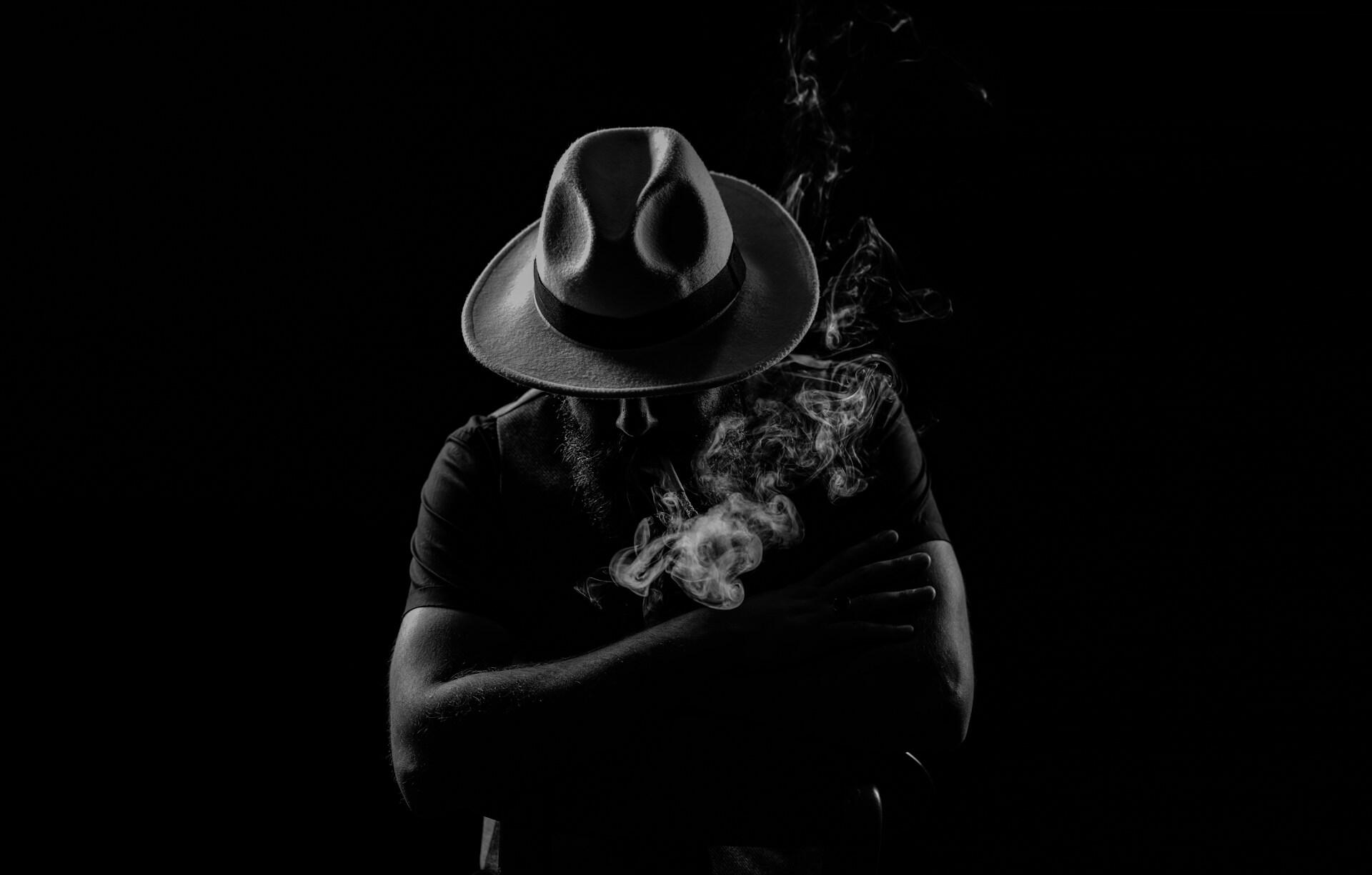a man in the hat on the totally black background
