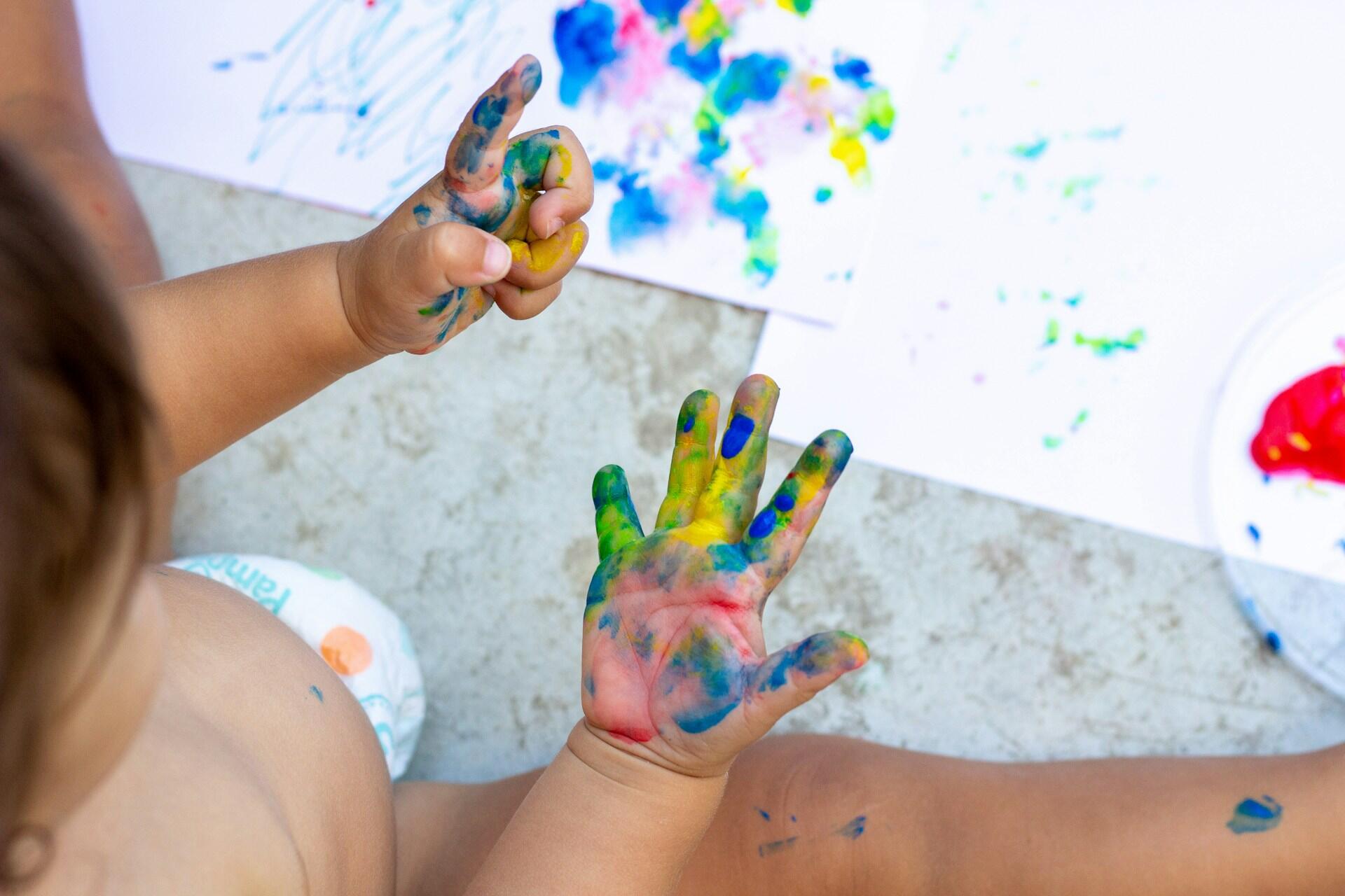 a baby kid is playing and painting