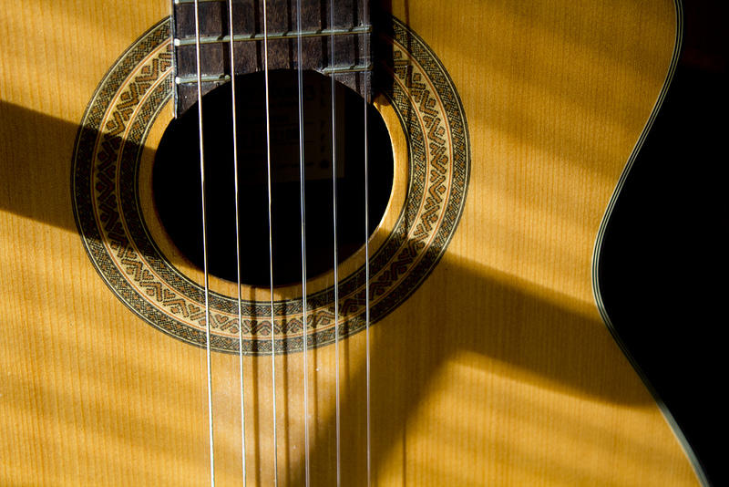 Sound hole and strings on classical guitar.