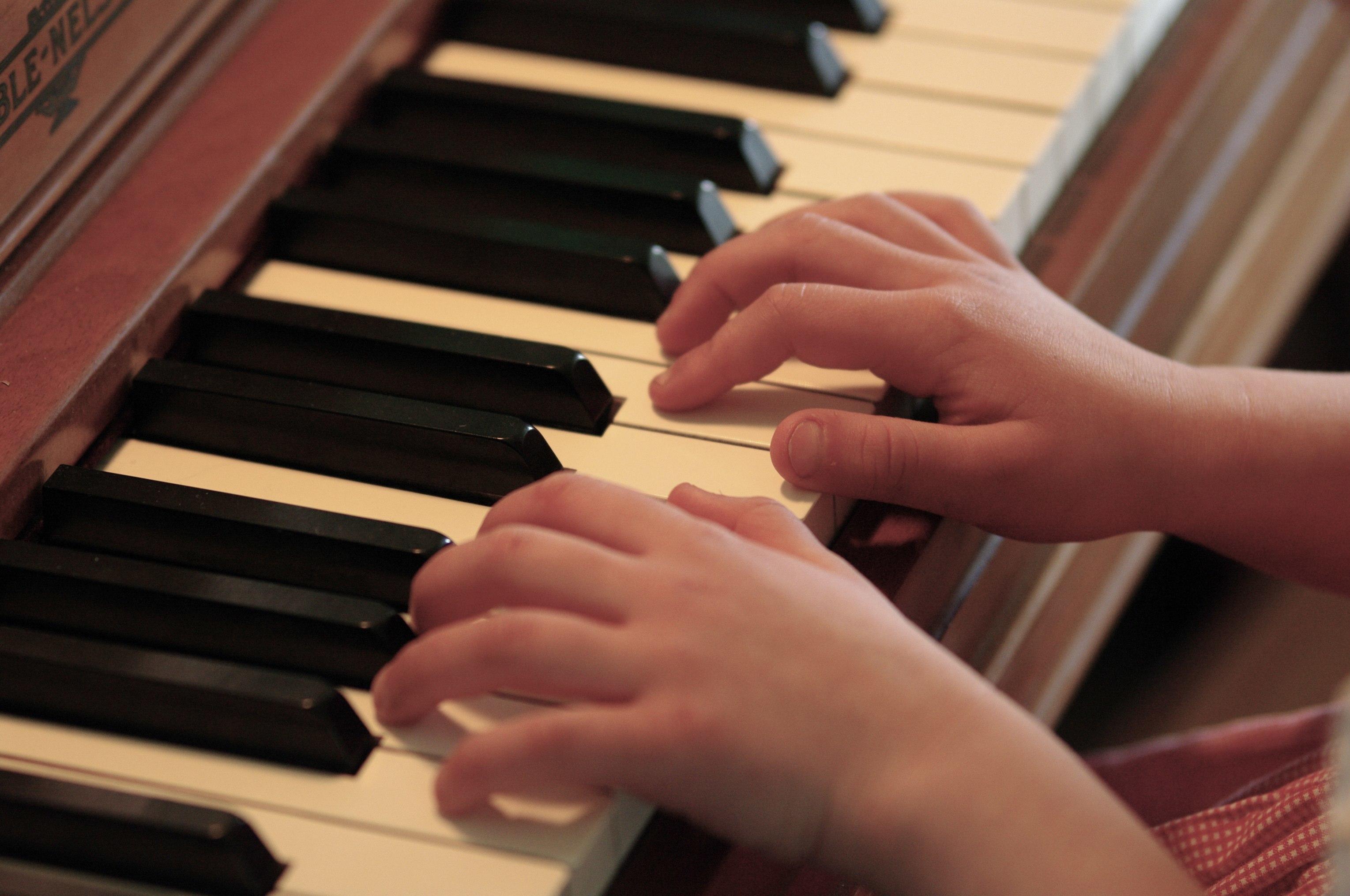student and teache learning piano