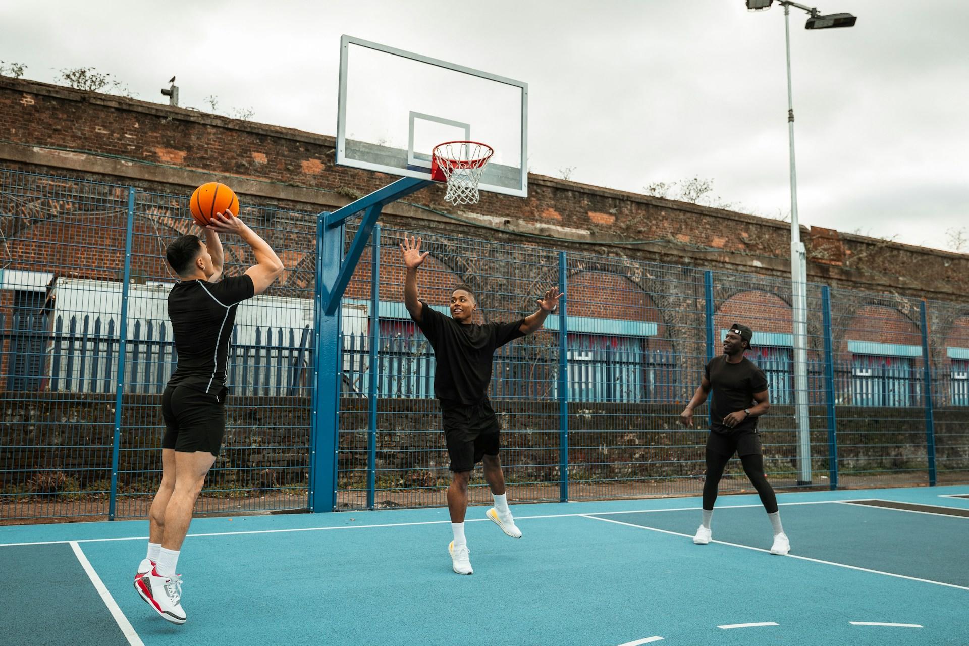 A group of people exercising by playing basketball.