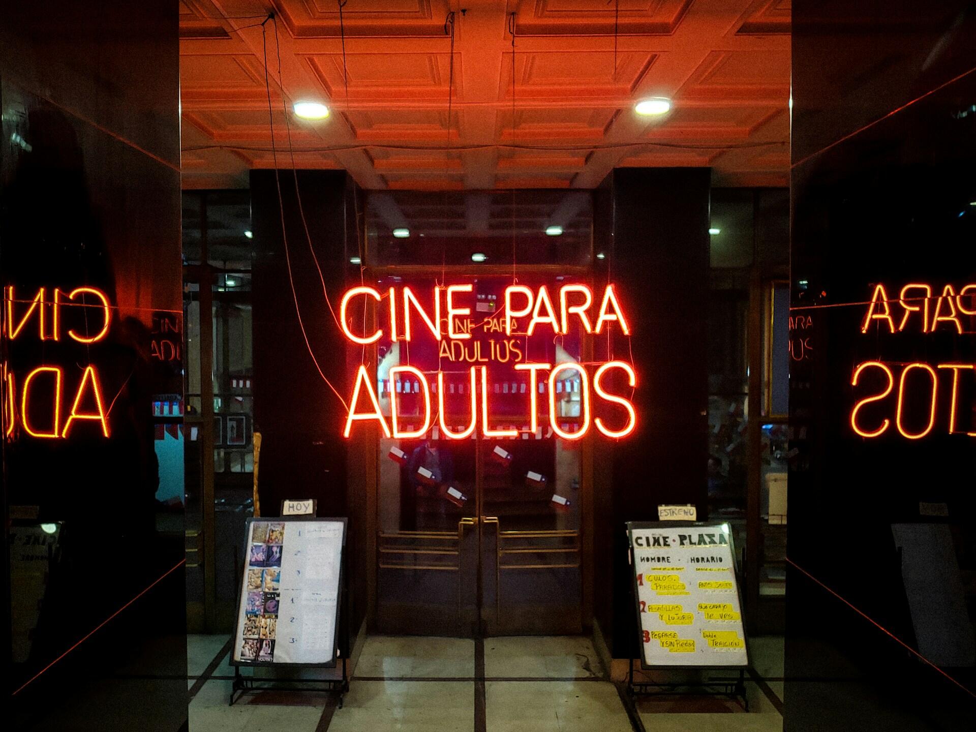 A sign in red that says Cine para adultos.