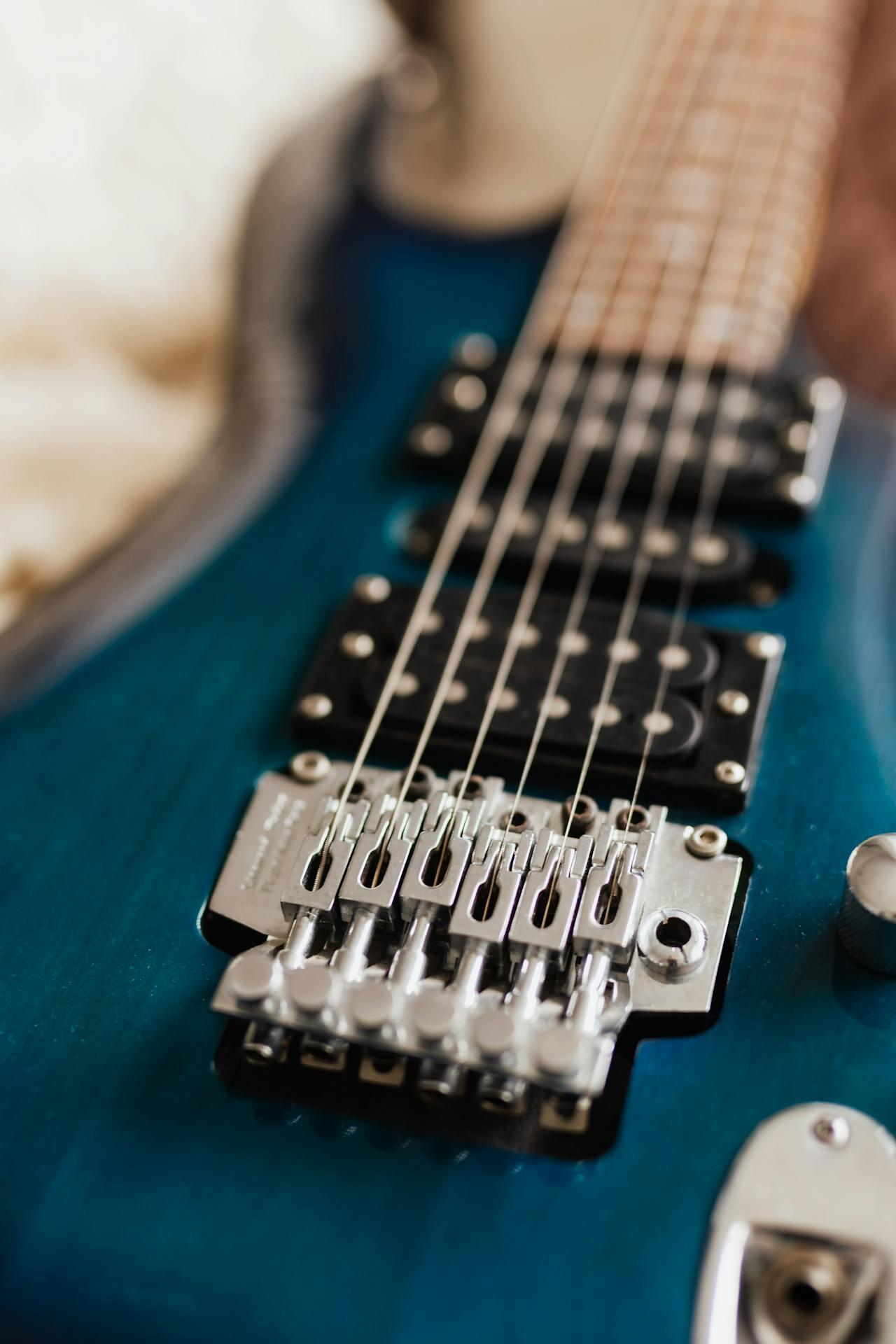 closeup photo of the bridge and pickups on a guitar with strings