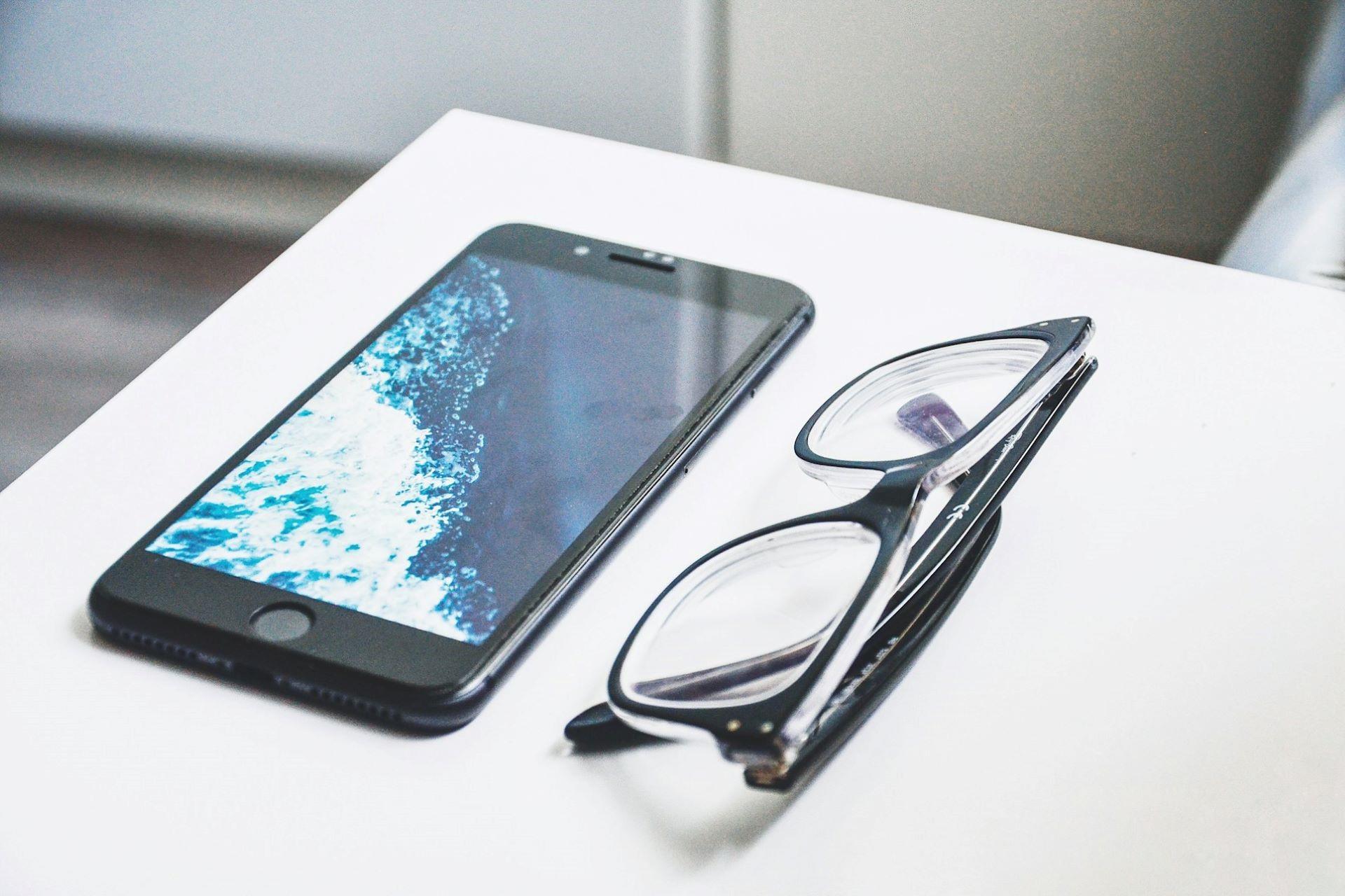 Some glasses next to an iPhone.