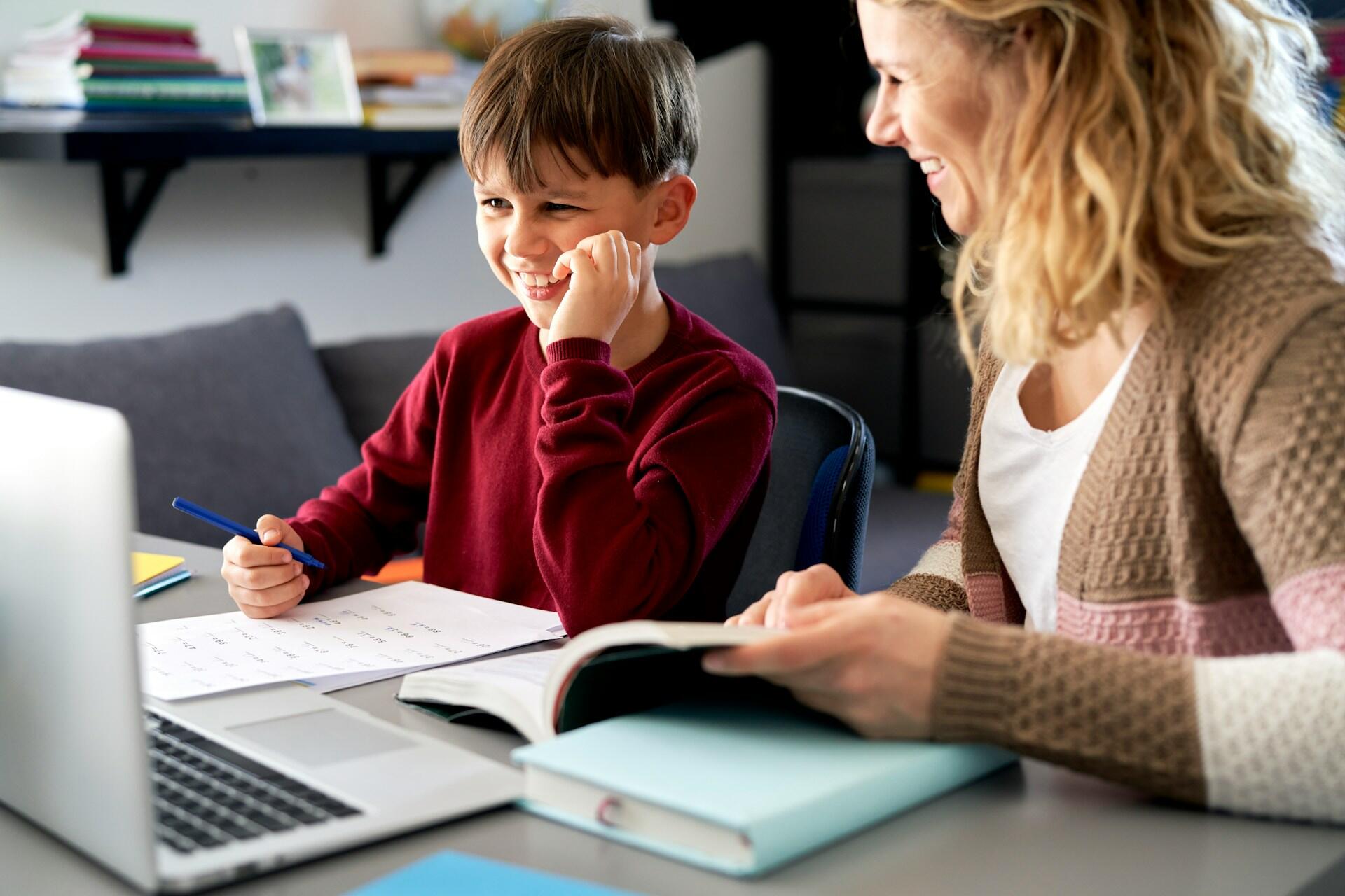 a smiling young student learning with his tutor