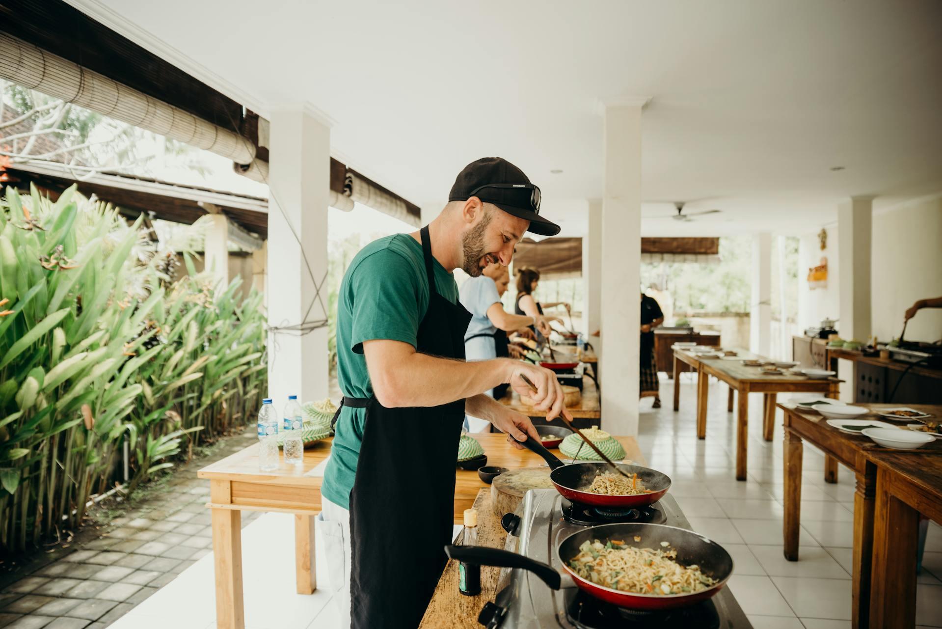 Students lined up for a cooking class, with a guy in a green shirt in the front.