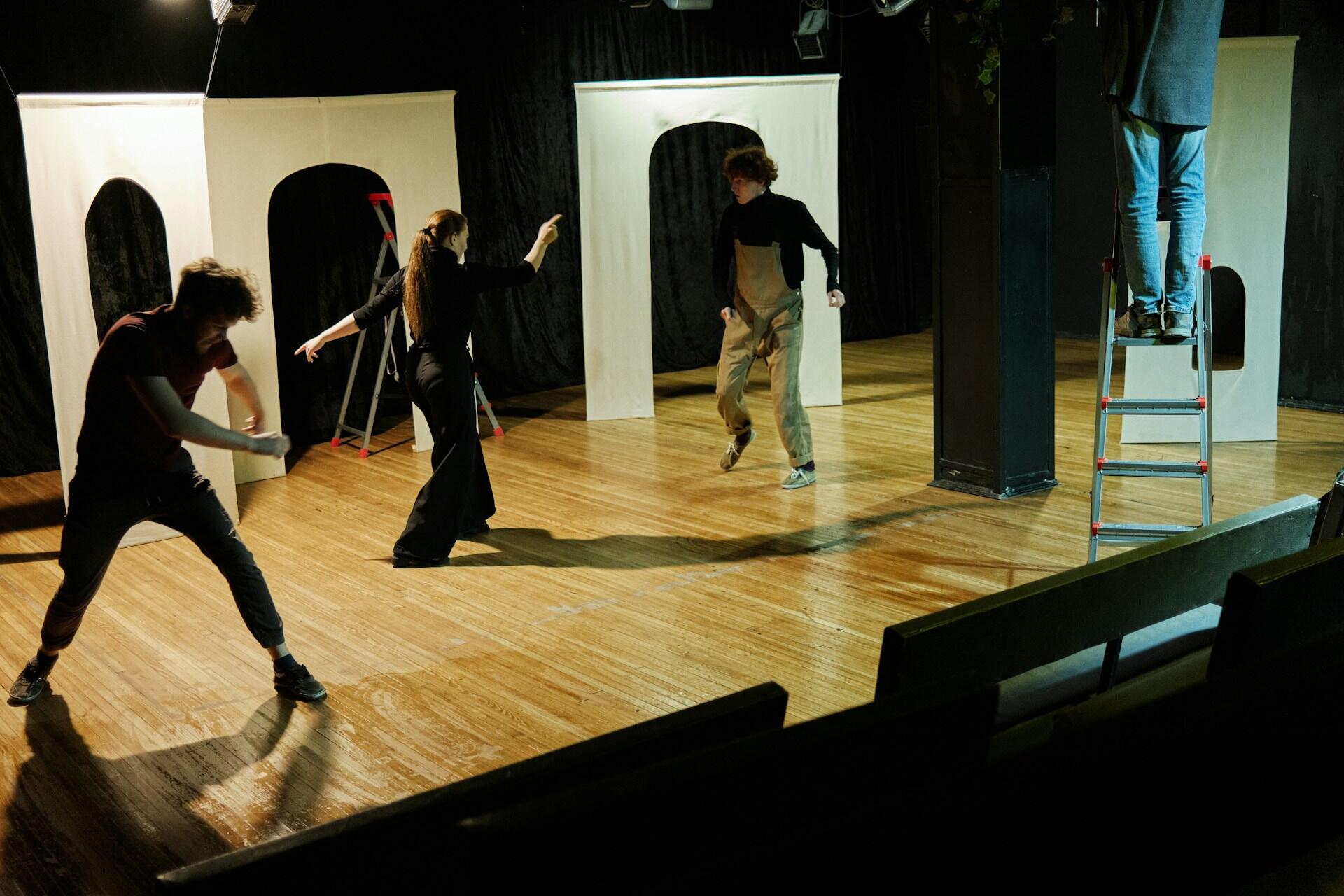 Three actors on stage performing.
