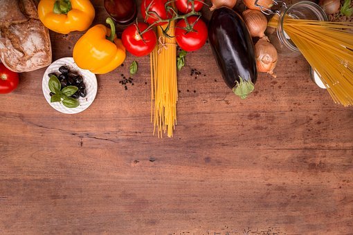 Vegetables, noodles, and herbs laid on a wooden table