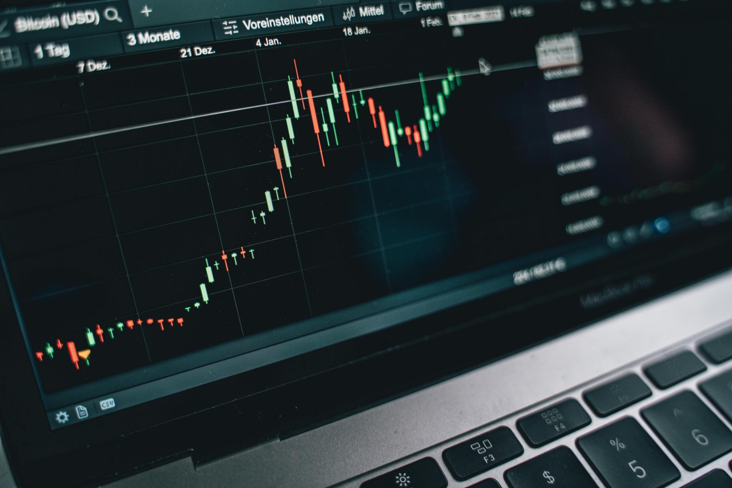 A laptop displaying a financial graph on its screen.