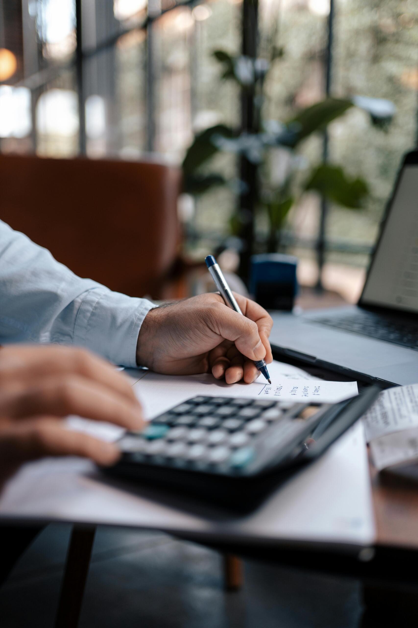 A person using a calculator while reviewing financial documents.