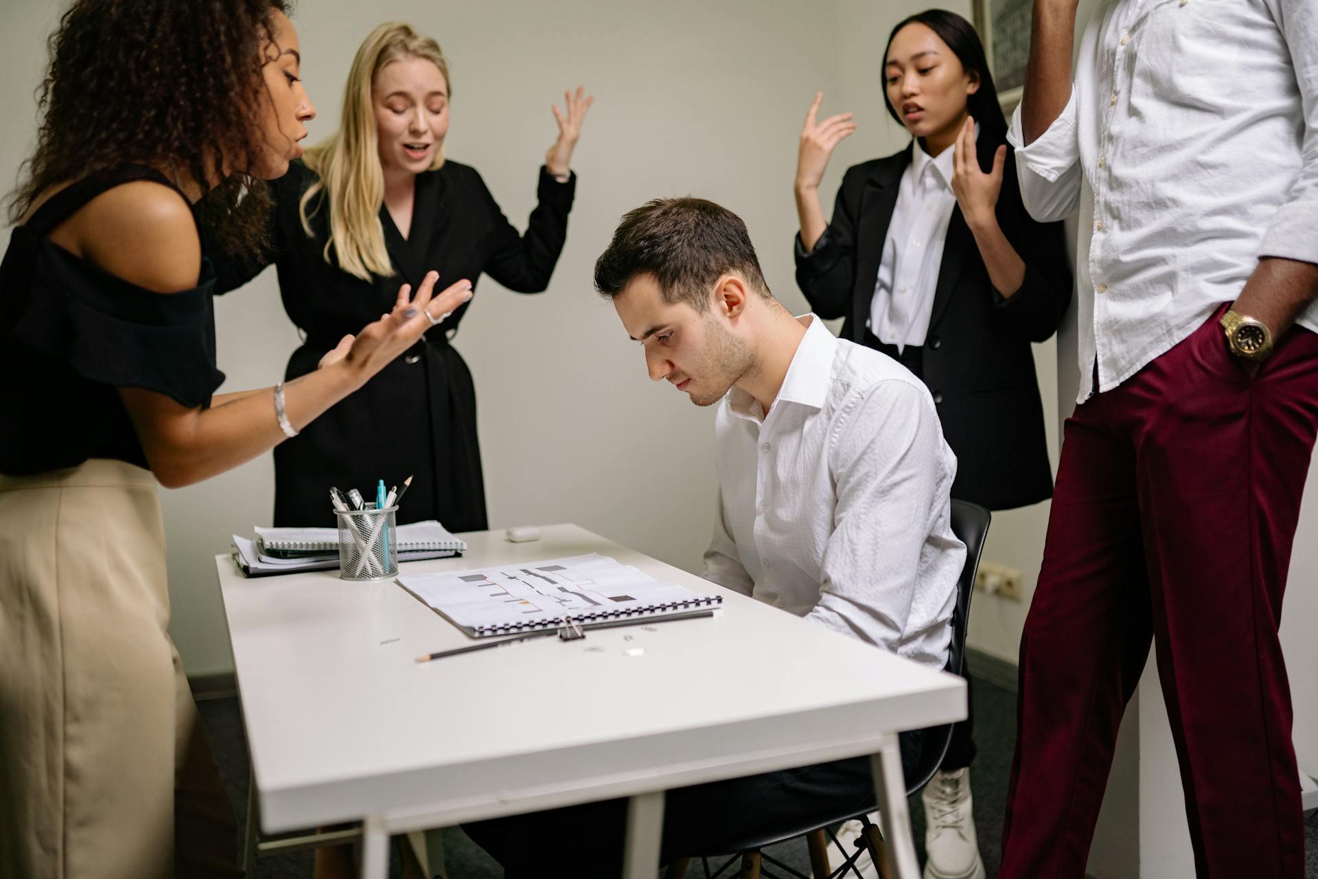 people in an office scolding one employee
