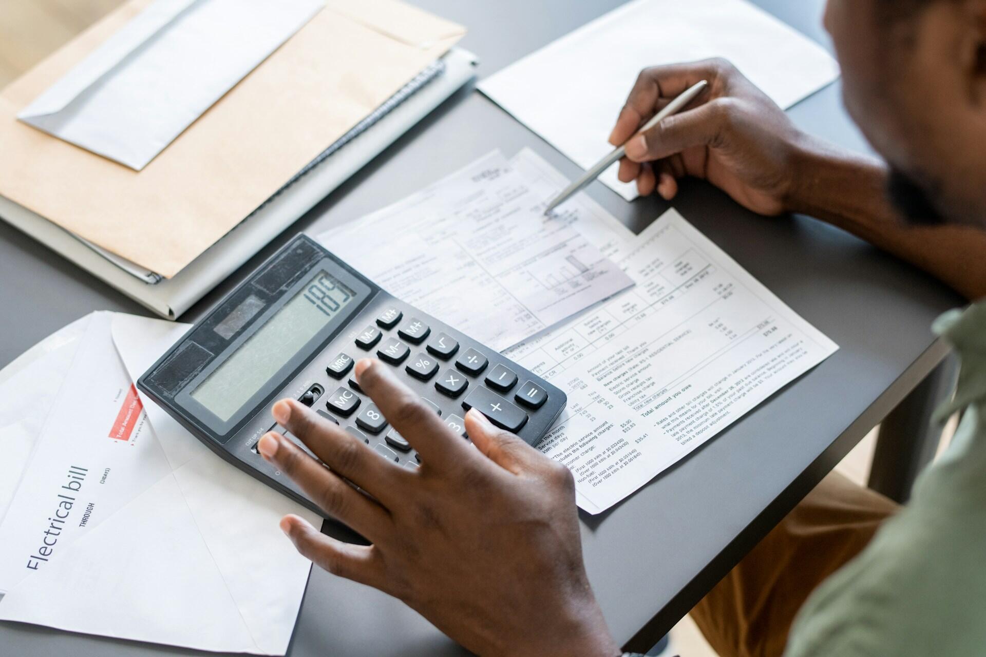 A man paying his bills and using a calculator.