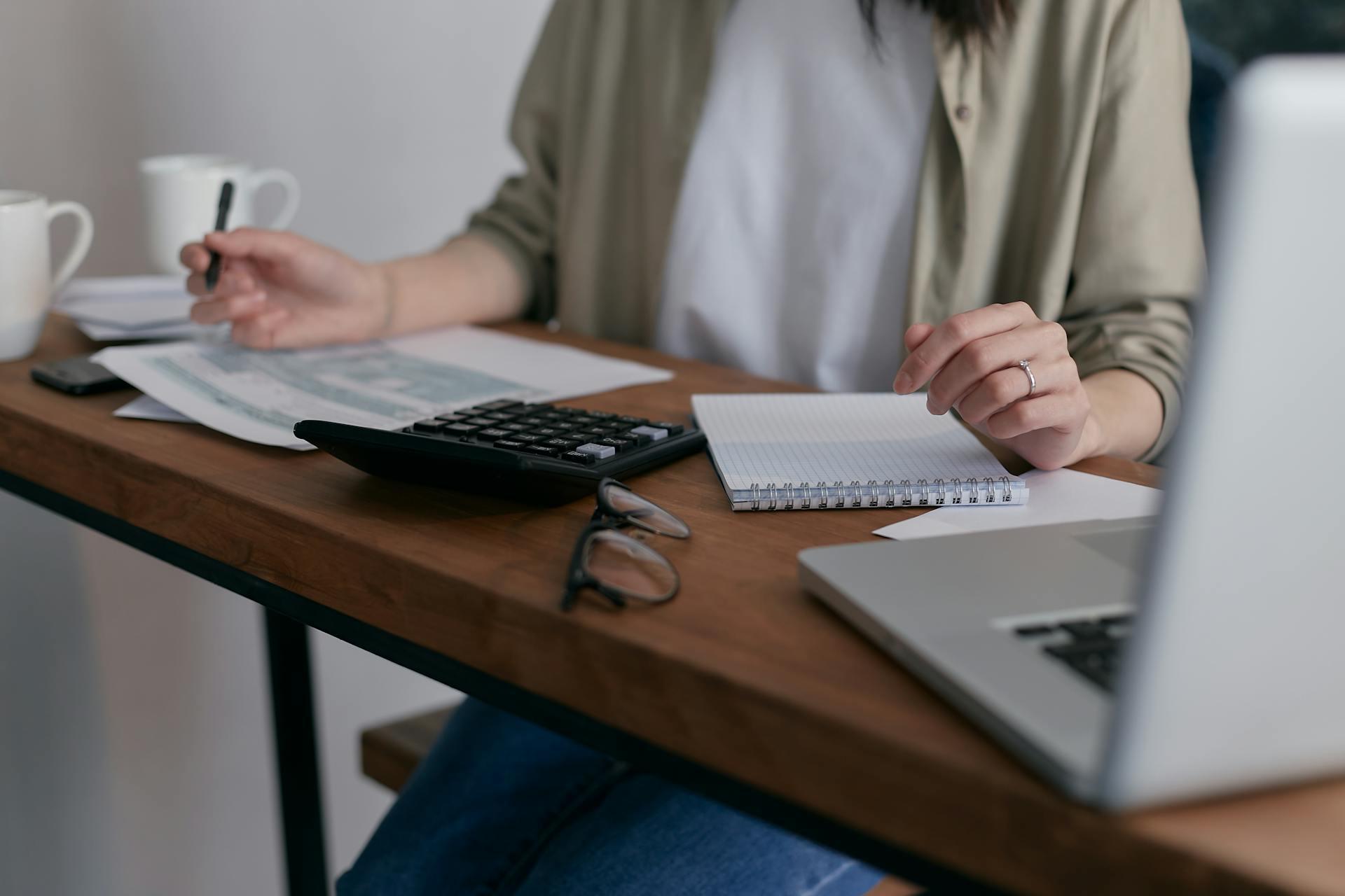A women studying with accounting worksheets at a desk.