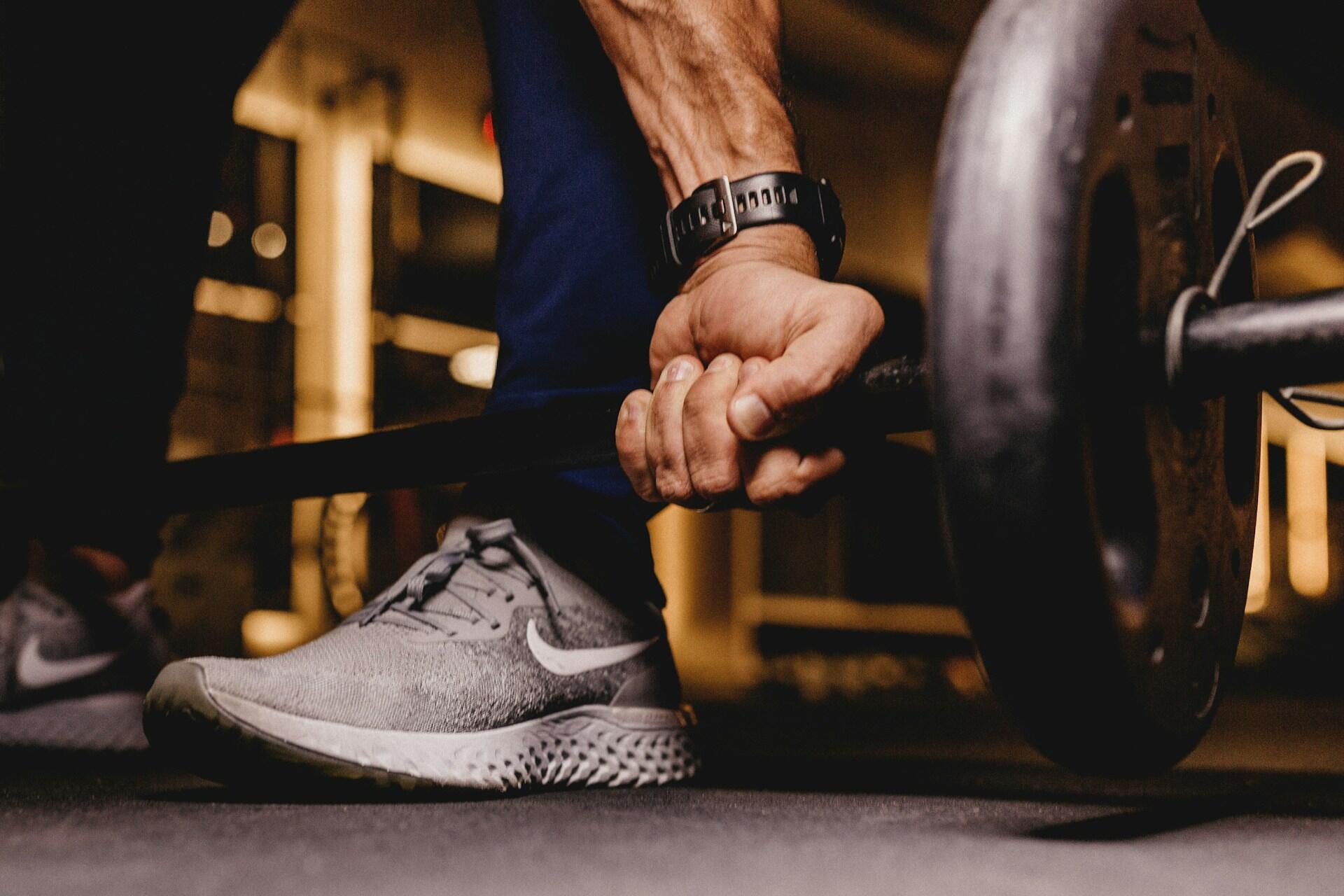 A man getting ready to pick up a bar and weights.
