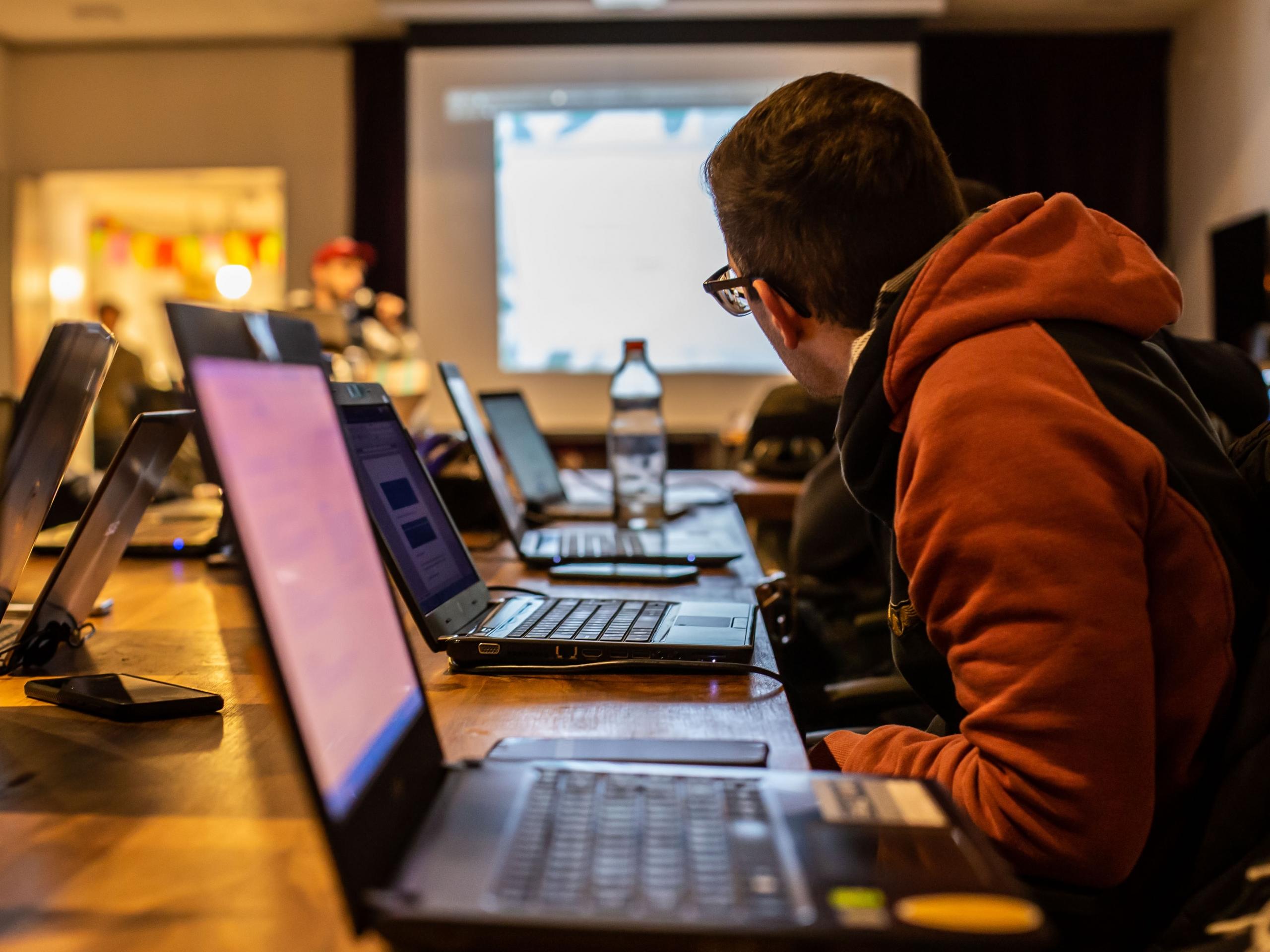 Students take down notes on their laptops as the professor presents