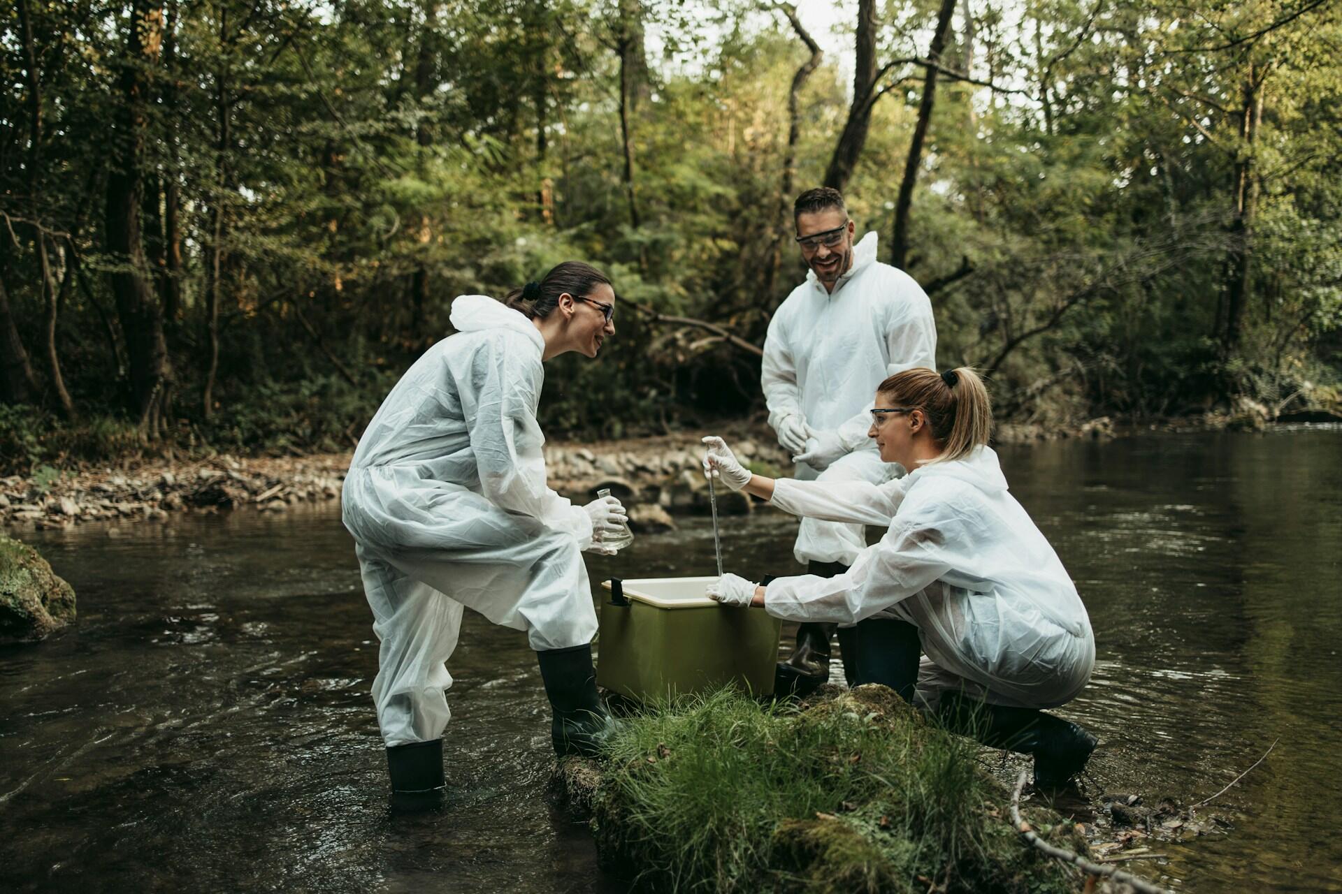 Three biologists taking samples at the river.