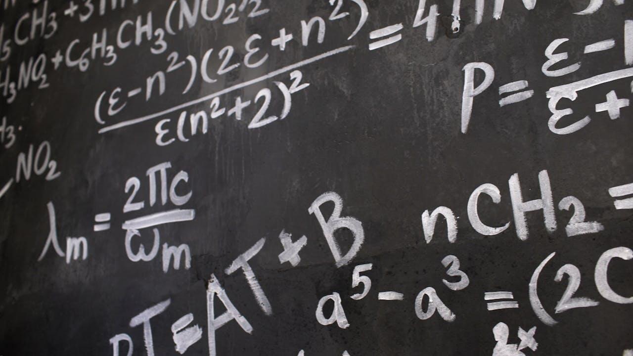 Math equations written on a chalkboard.