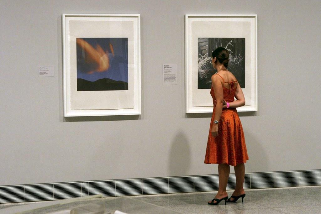 Woman standing in front of photographs at an exhibition