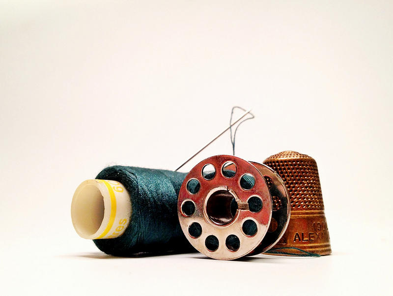 Image of thread, needle and thimble