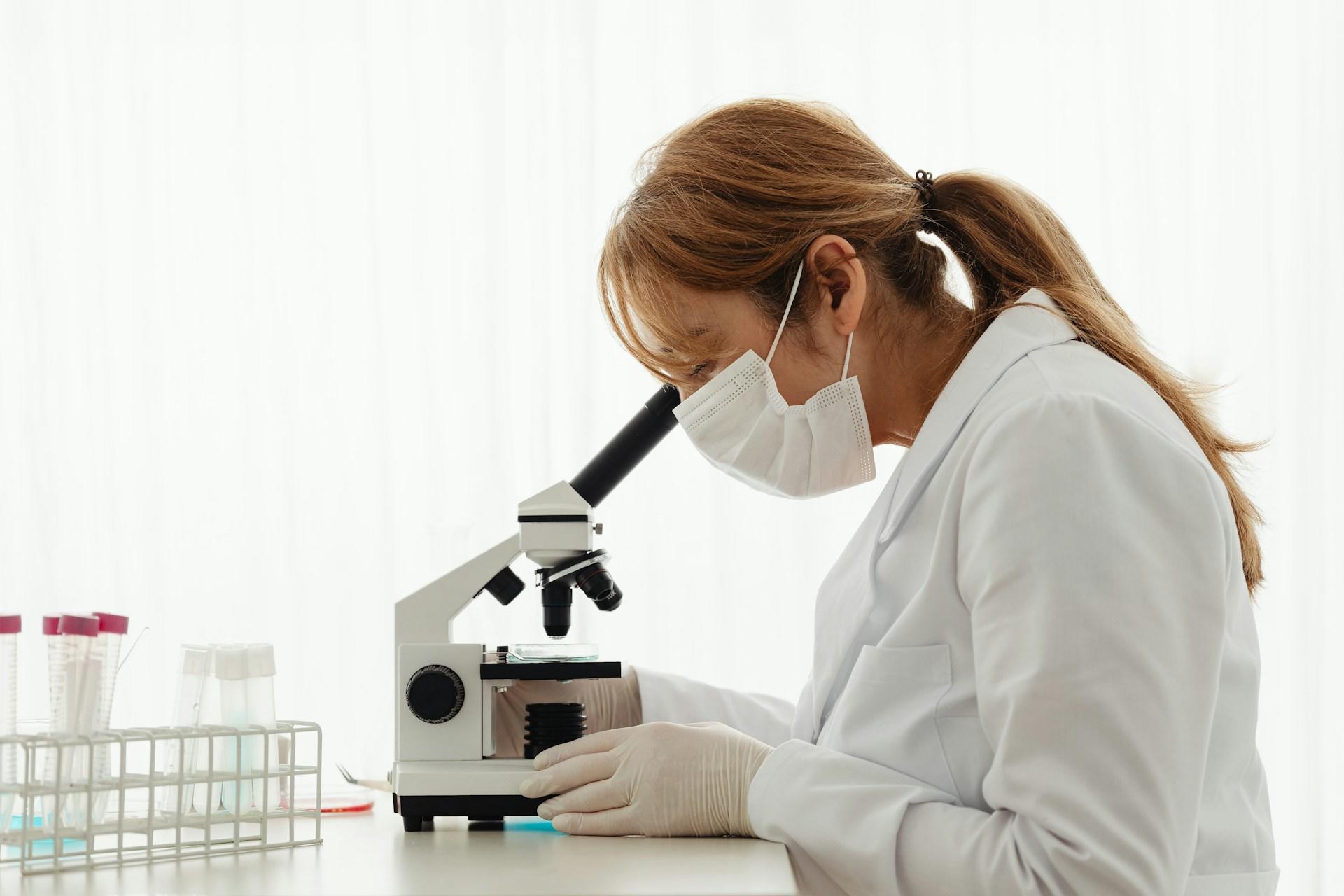 A forensic biologist looking into a microscope.