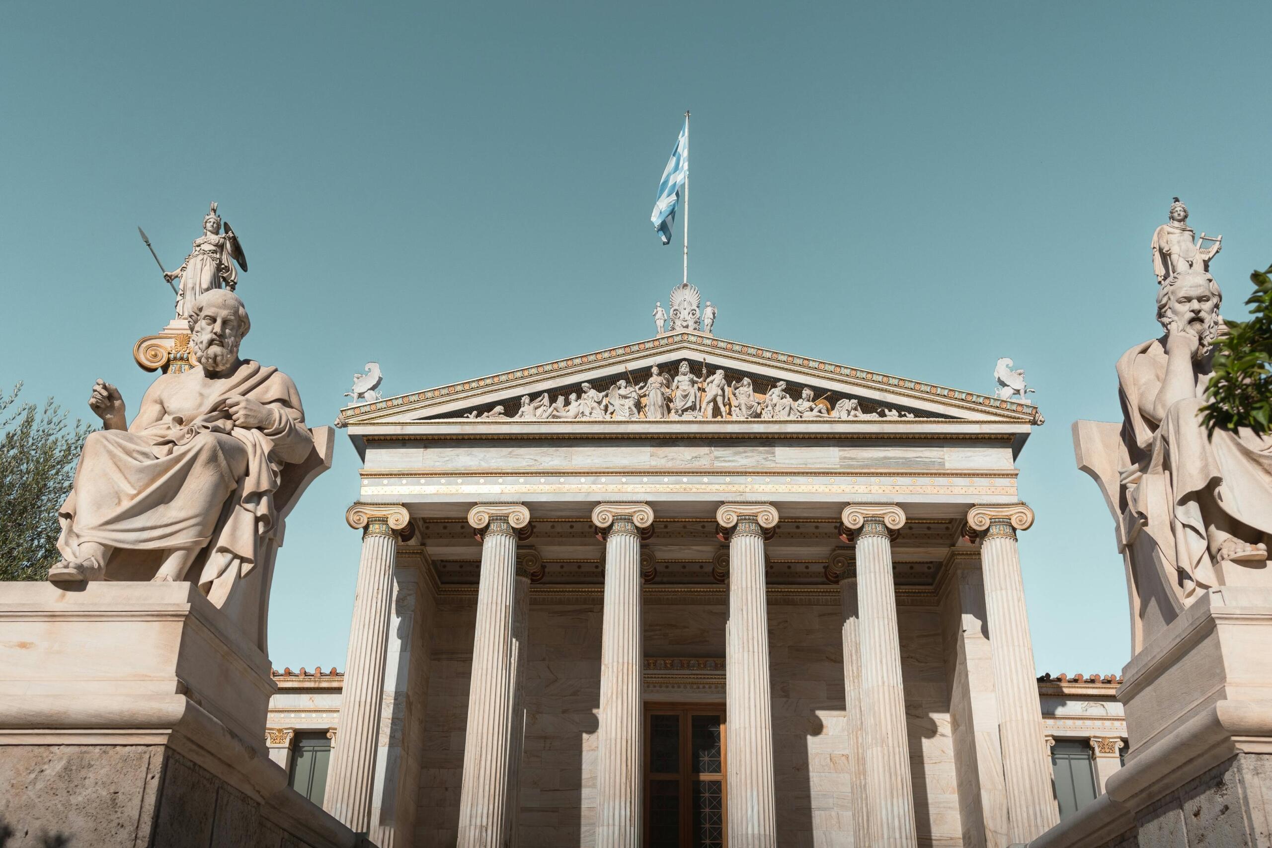 Neoclassical building of the Academy of Athens with statues and columns.