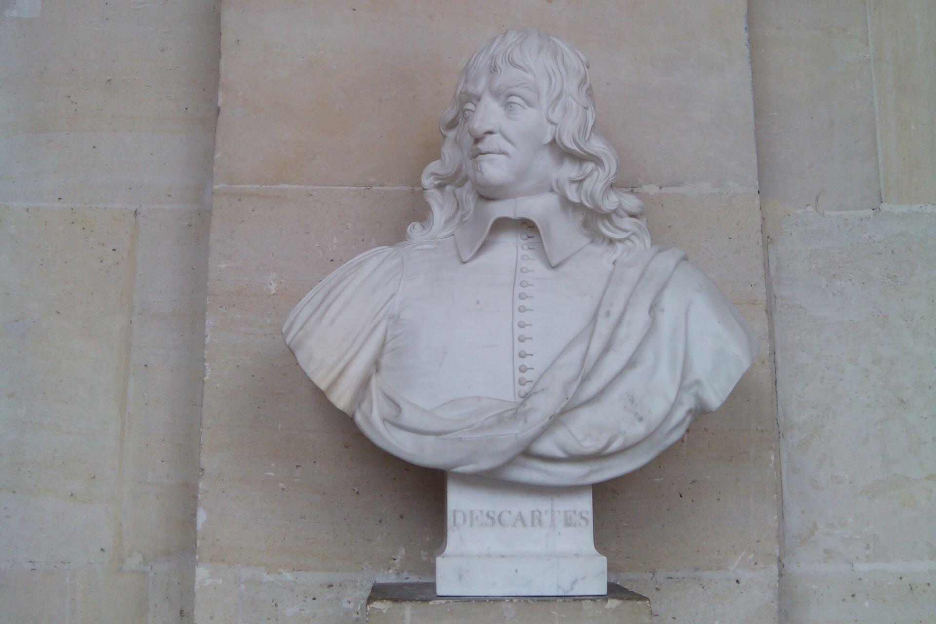 White marble bust sculpture of René Descartes mounted against a stone wall
