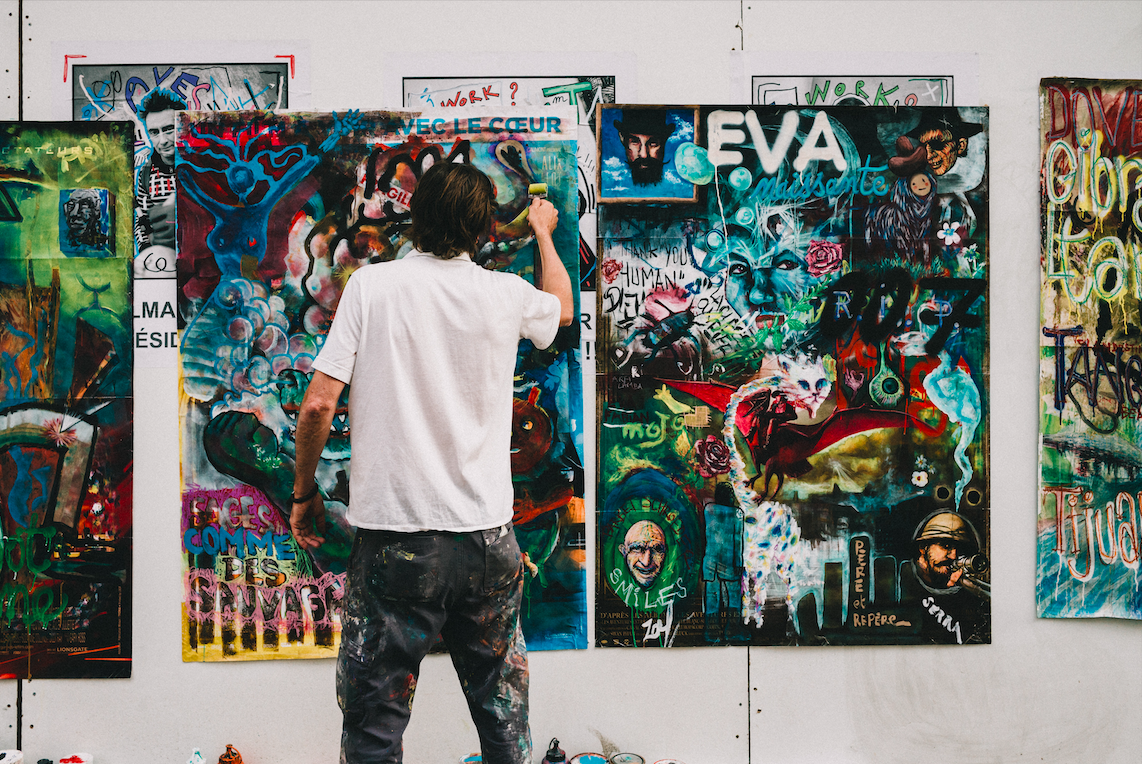 Man standing in front of a large canvas painting.