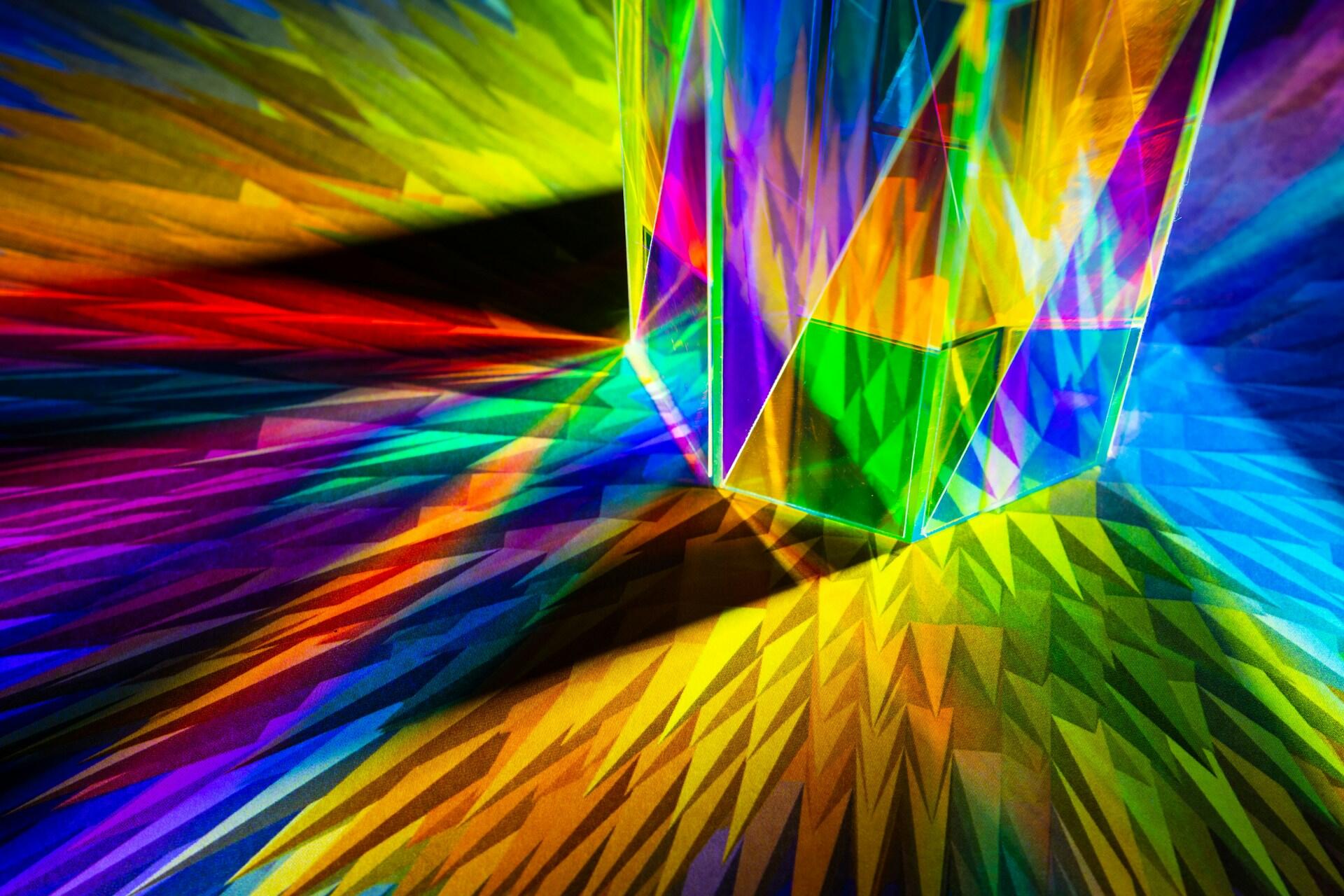 Glass prism splitting white light into bright rainbow colors
