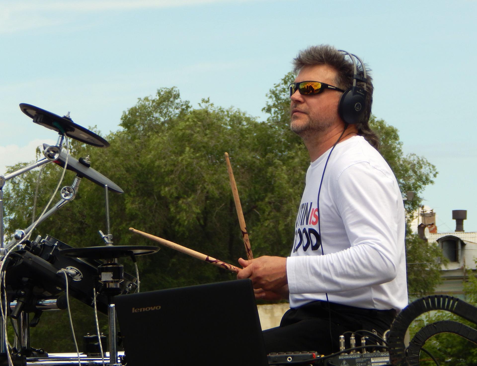 Man playing drums outside in shades