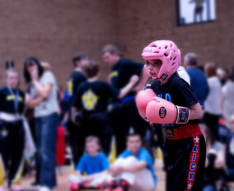 Girl in pink helmet and boxing gloves