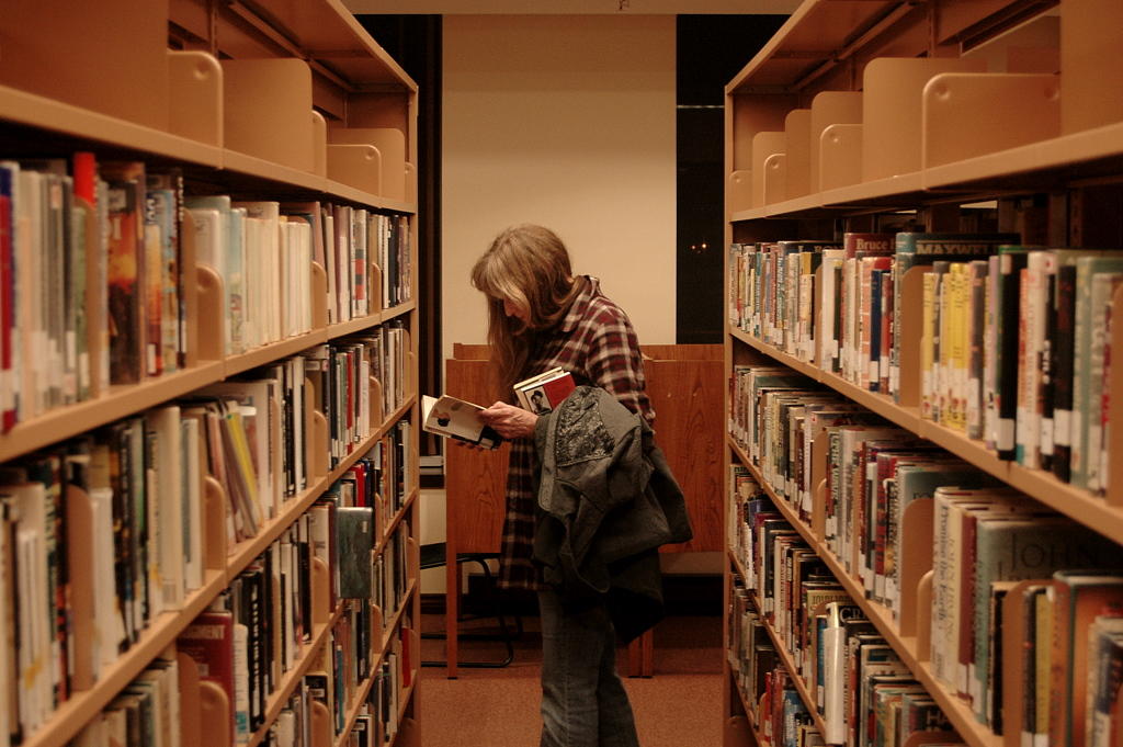 A student looks through a book in the library.